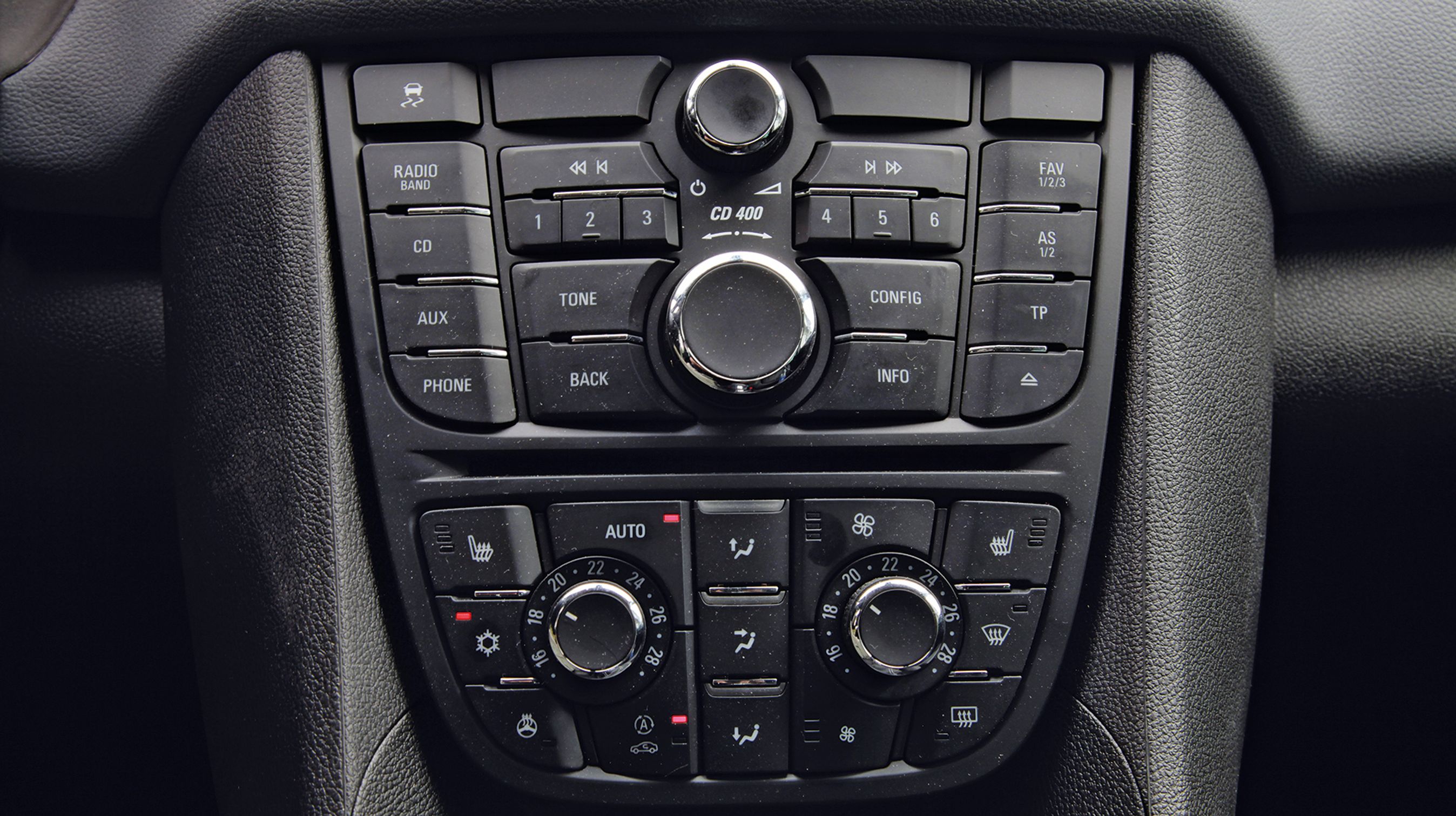 Midterkonsol med betjening af radio og klimaanlæg. Det giver mange knapper, som man bør studere, før man første gang begiver sig af sted i bilen.