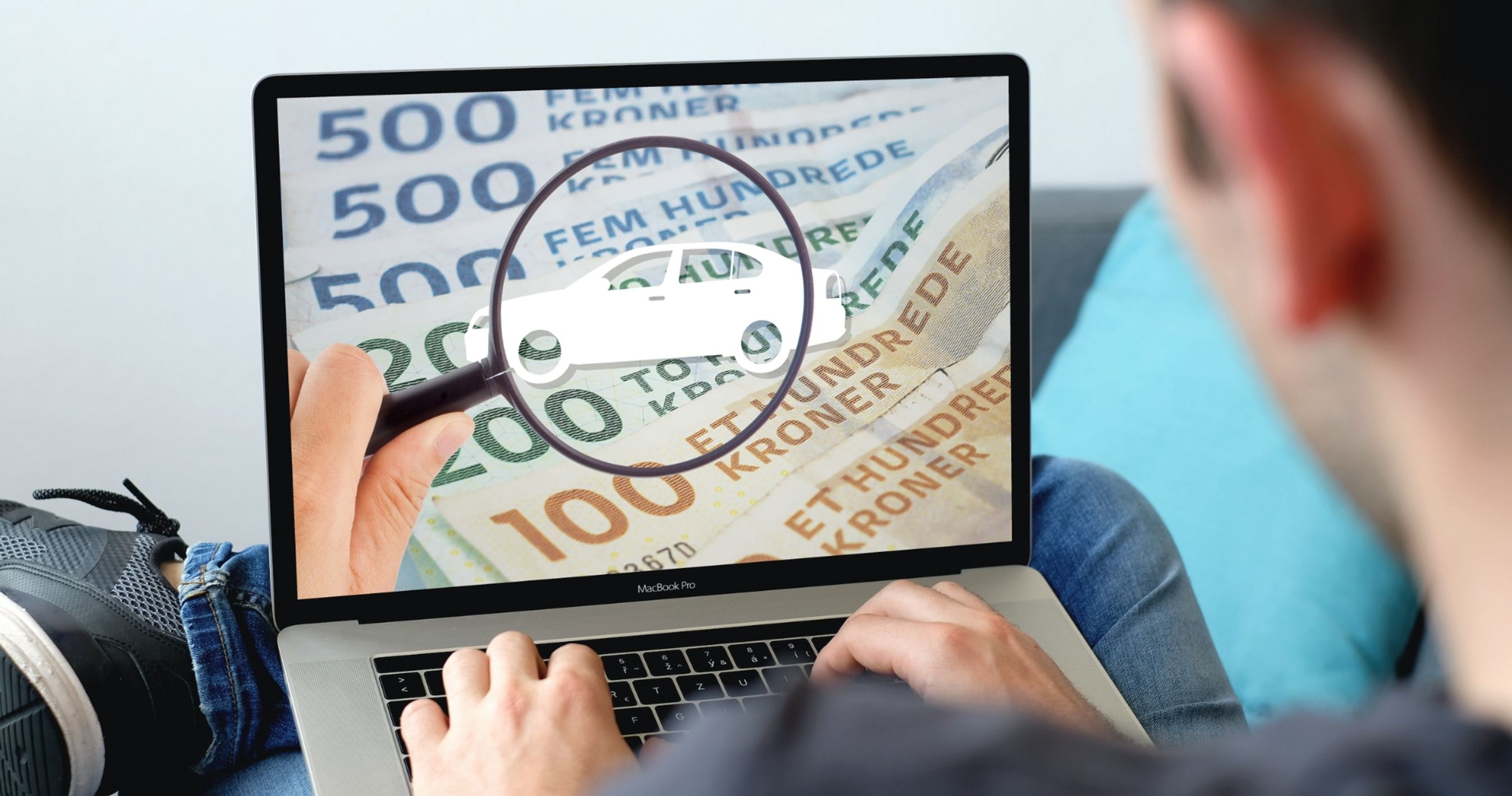 Mand sidder og ser på computerskærm med pengesedler.