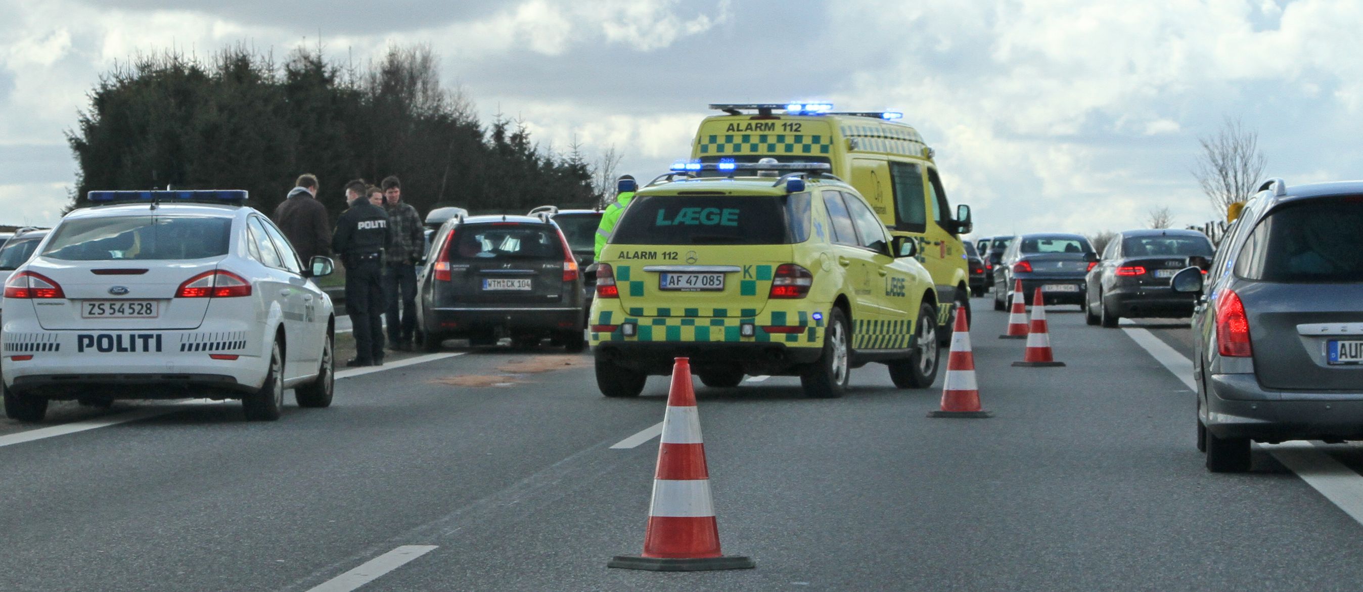 Politi og ambulance ved ulykke på motorvej.