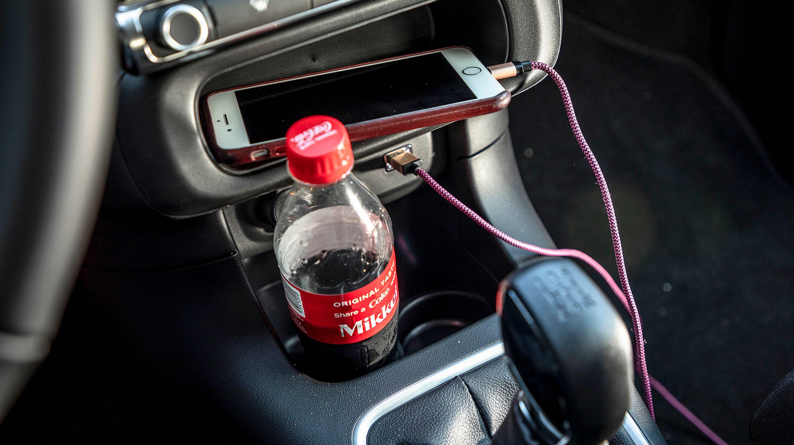 Kopholderne er placeret, så flasker står skævt i holderen. Dog er mobilhylden smart til hverdag, store mobiler kan dog ikke være der med ladestik. 