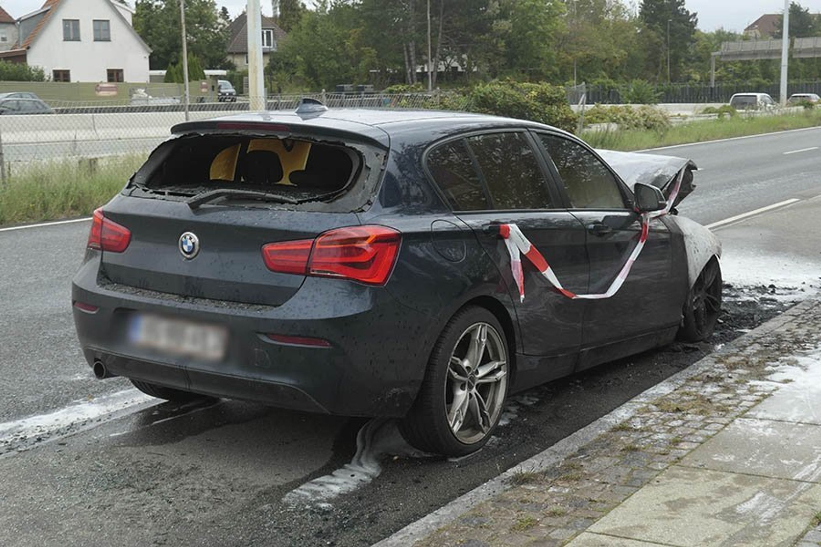 Udbrændt BMW står i vejsiden langs motorvej