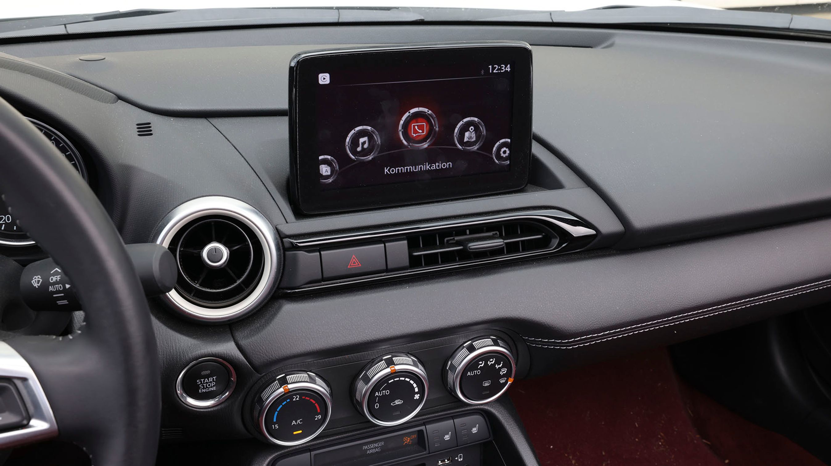 Der er trykskærm, altså når bilen holder stille. Når du kører, skal du bruge den sølvfarvede drejeknap ved gearstangen til at betjene infotainmentsystemet.