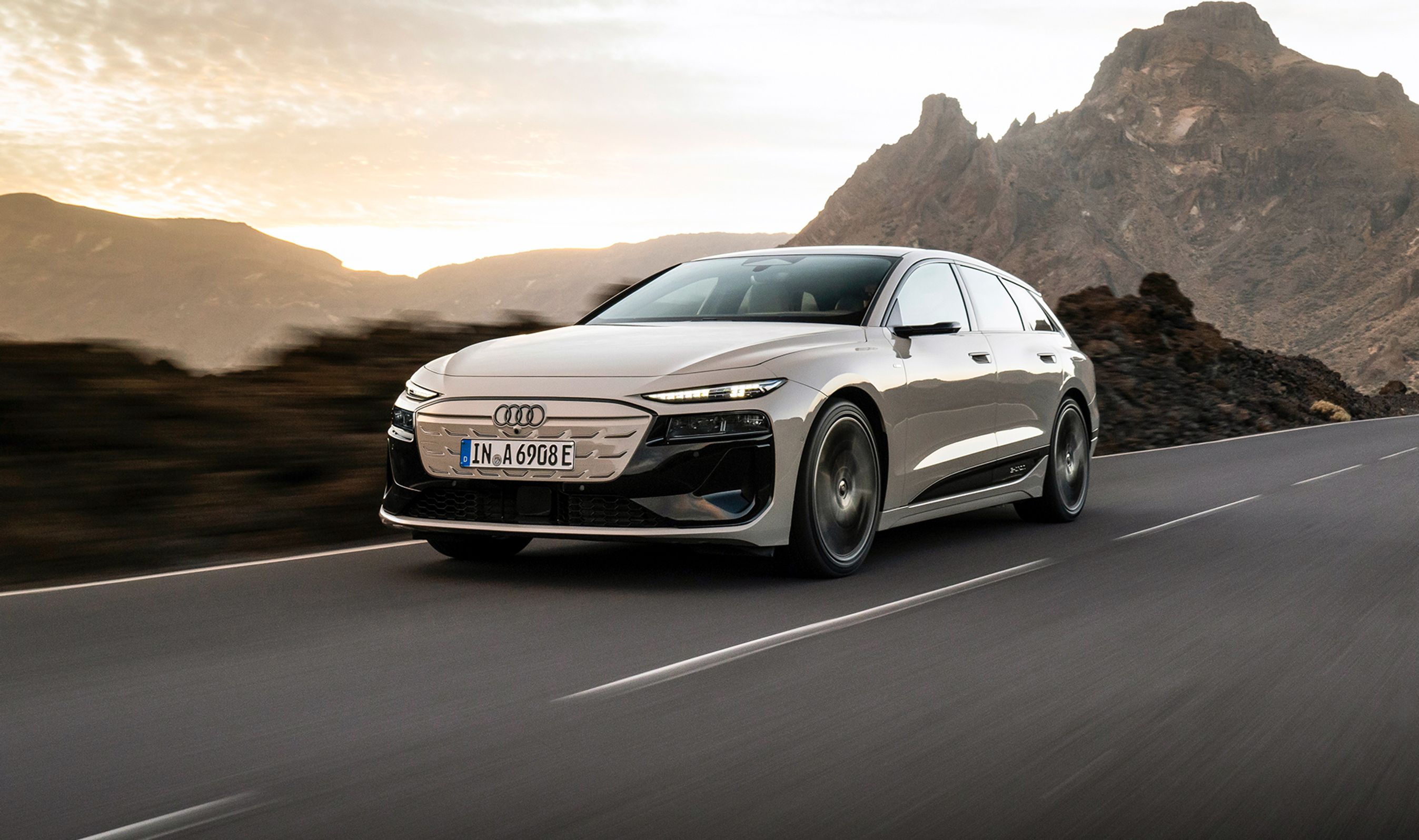 Audi A6 e-tron i fart på vej med klippeparti i baggrunden