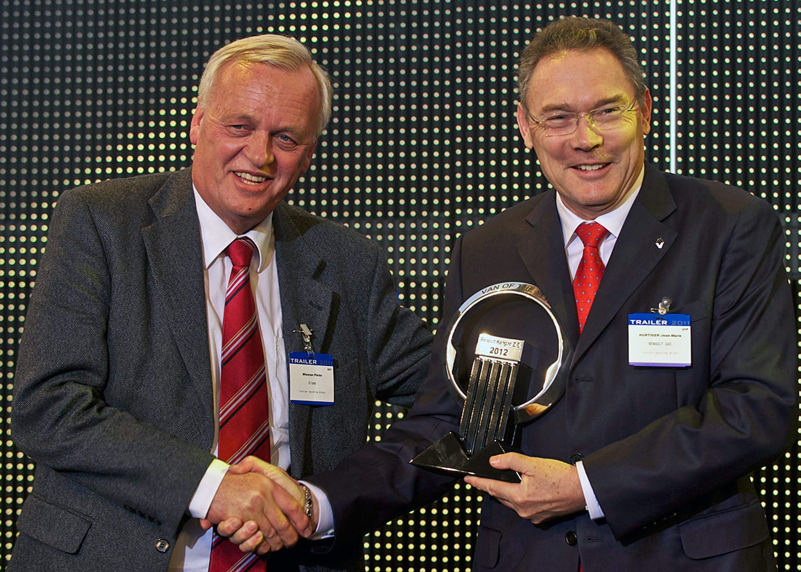 Renaults chef for varevogne, Jean Marie Hurtiger (t.h.), modtager ved en ceremoni i Belgien det synlige bevis hæderen. Trofæet overrækkes af varevognsjuryens formand, Pieter Wieman.