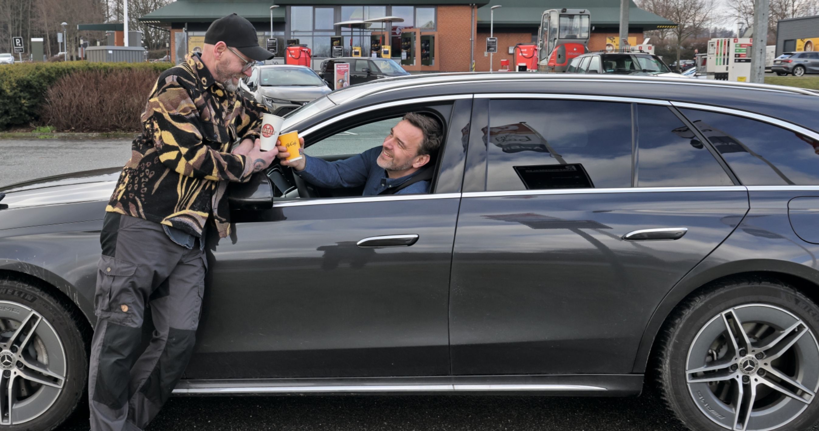 De to kaffetestere smager på kaffe på rasteplads