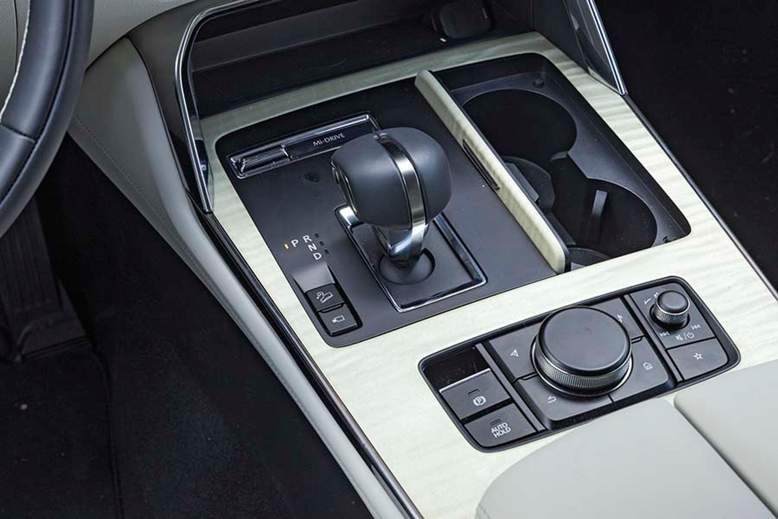 Gearstangen er besværlig og kræver tilvænning, idet den skal flyttes sideværts fra R til P, når man parkerer. Der er fine kopholdere til højre for gearstangen.