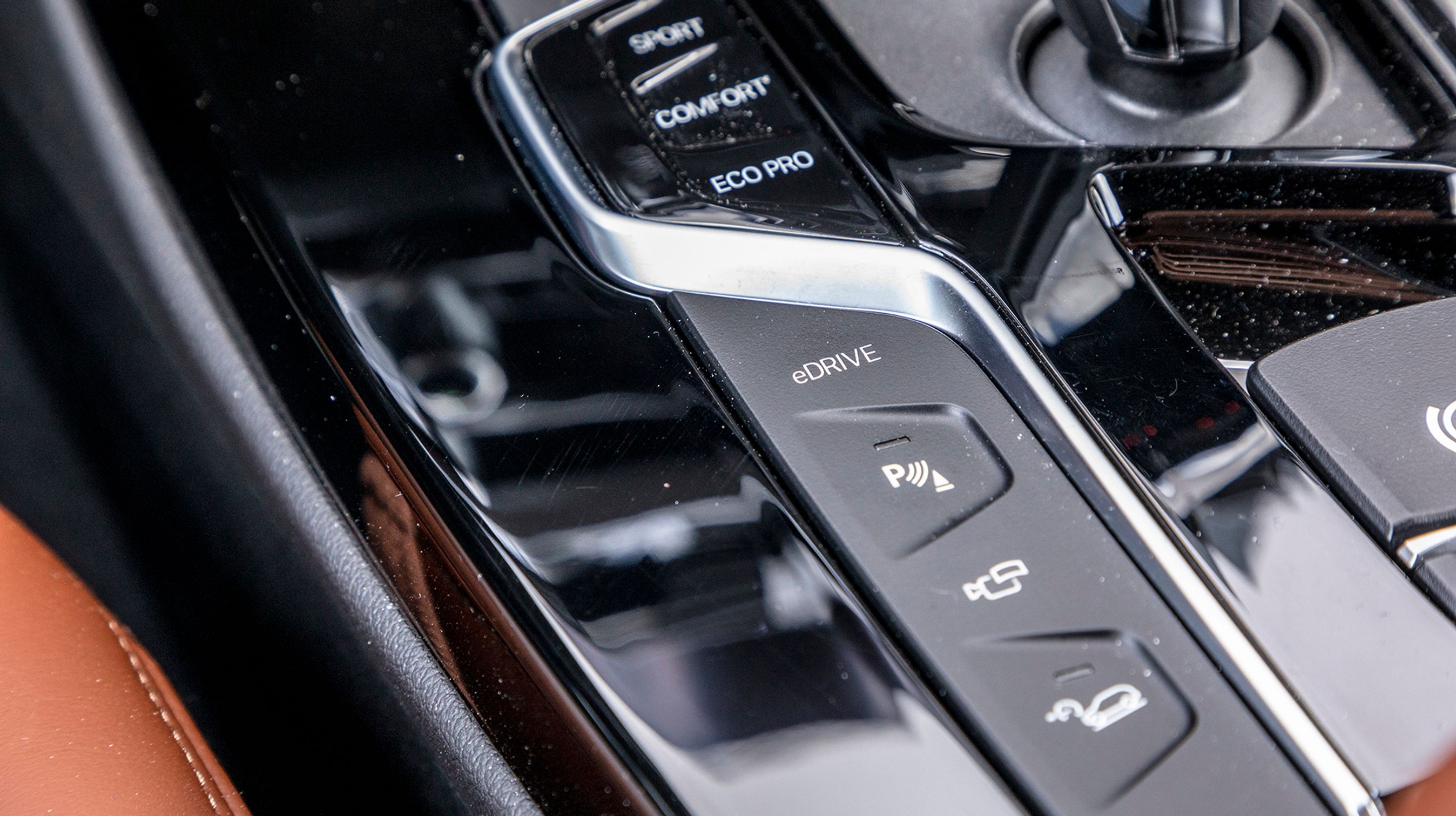 Fra eDRIVE-knappen til venstre for gearstangen kan man bestemme, om bilen skal køre på el, på benzin, eller om den selv skal finde ud af, hvad der er bedst (hybriddrift).