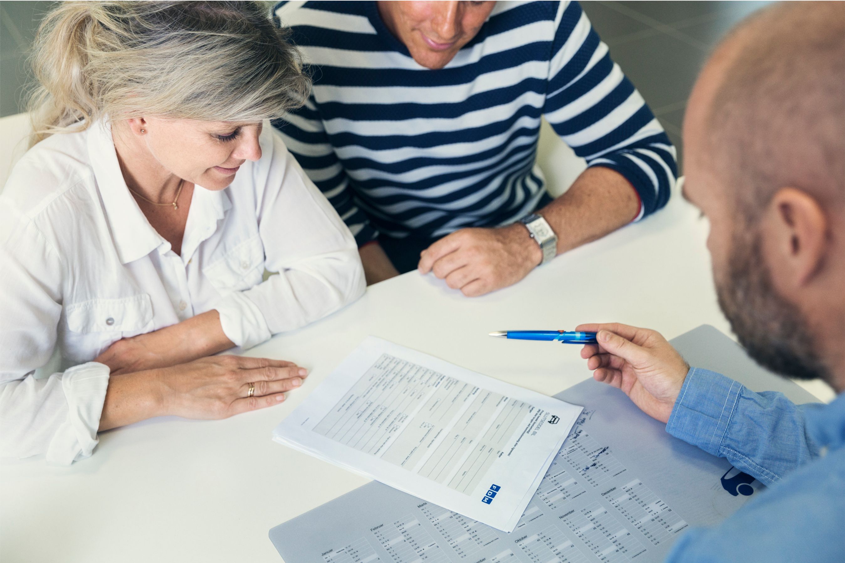 Billede af et par, der underskriver slutseddel hos en bilforhandler