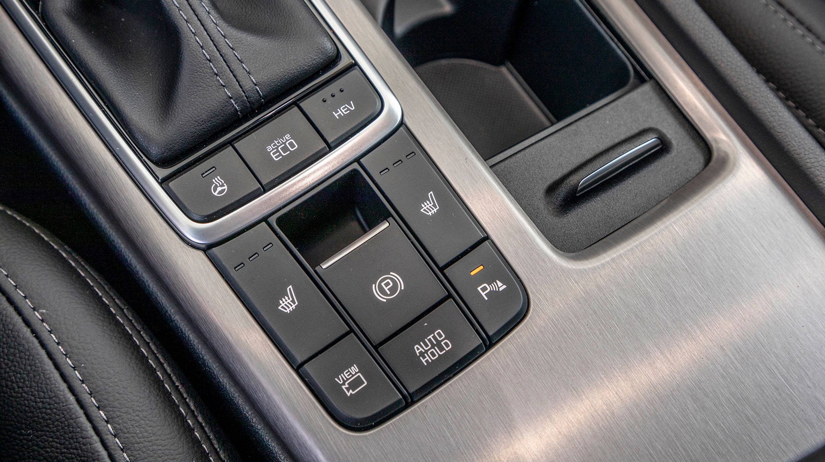 Bag gearvælgeren kan du aktivere rat- og sædevarme, men det også her, du kan vælge, at bilen skal køre på strøm alene og manuelt aktivere kameraerne uden på bilen. 