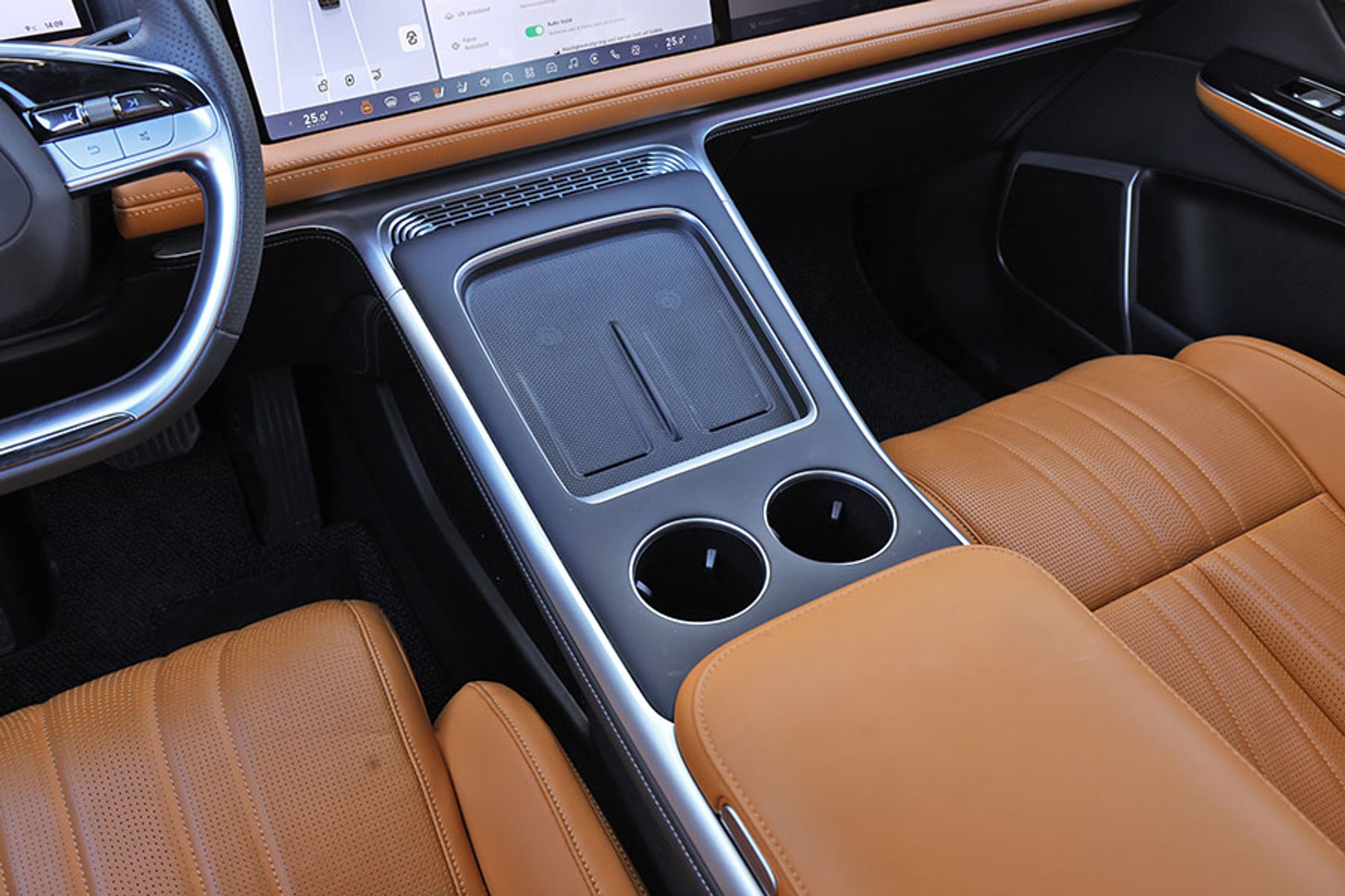 Indretningen omkring føreren er med to gode trådløse mobilladere med køling og to fine kopholdere uden køling. Der kunne godt være mere fralægningsplads til pung, nøgler og andre ting, man har med ind i bilen.