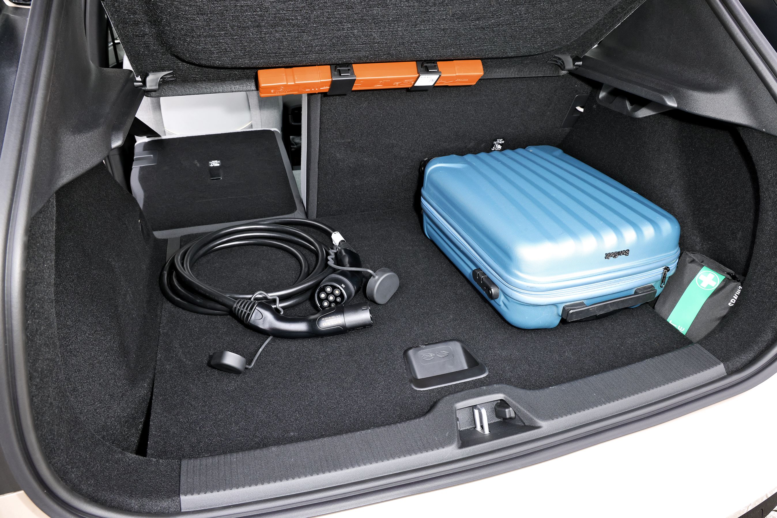 Bagagerum med blå kuffert og ladekabel i en Volvo EX30