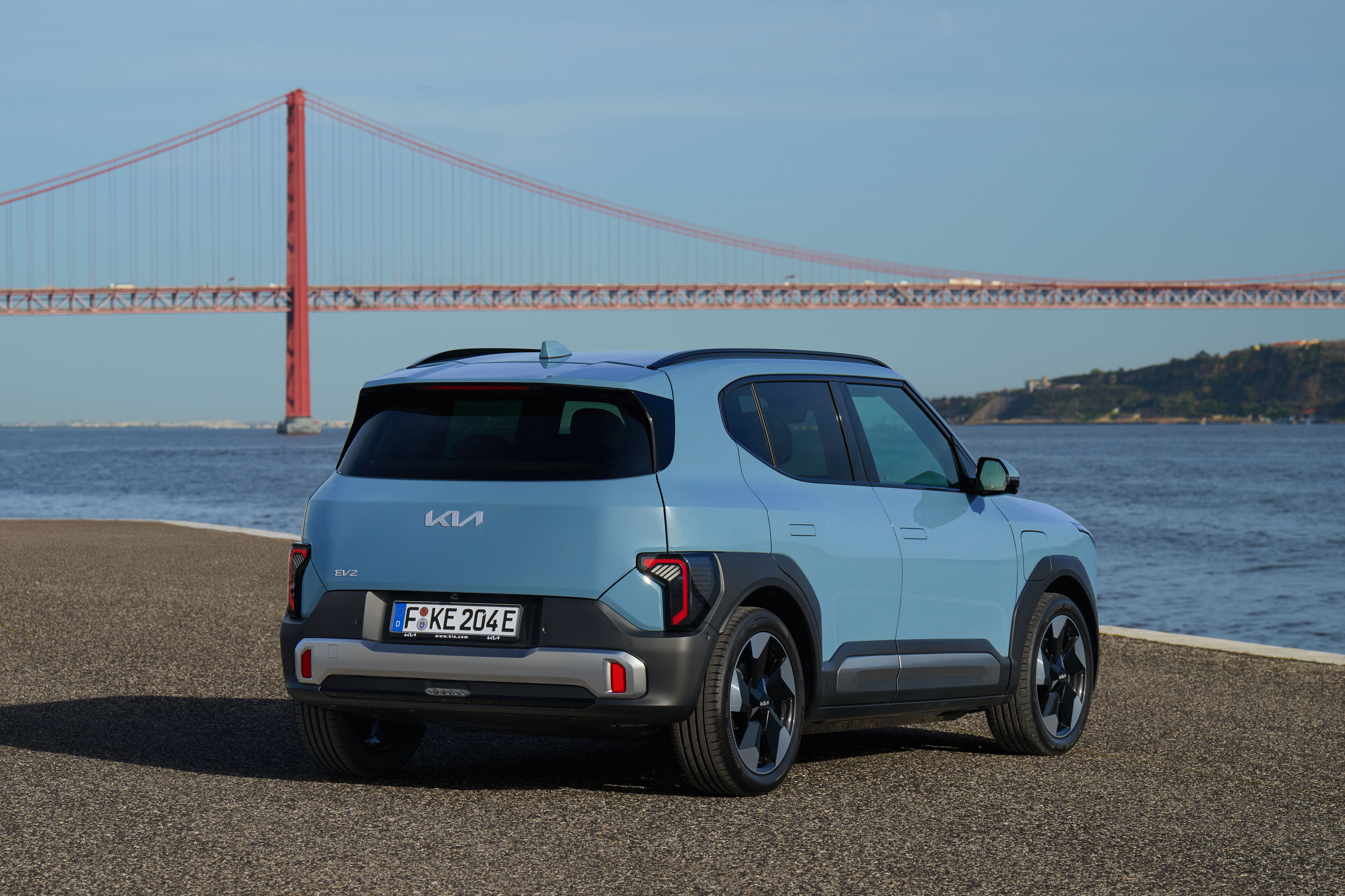 Kia EV2 set bagfra, mens den holder med bro og hav i baggrunden