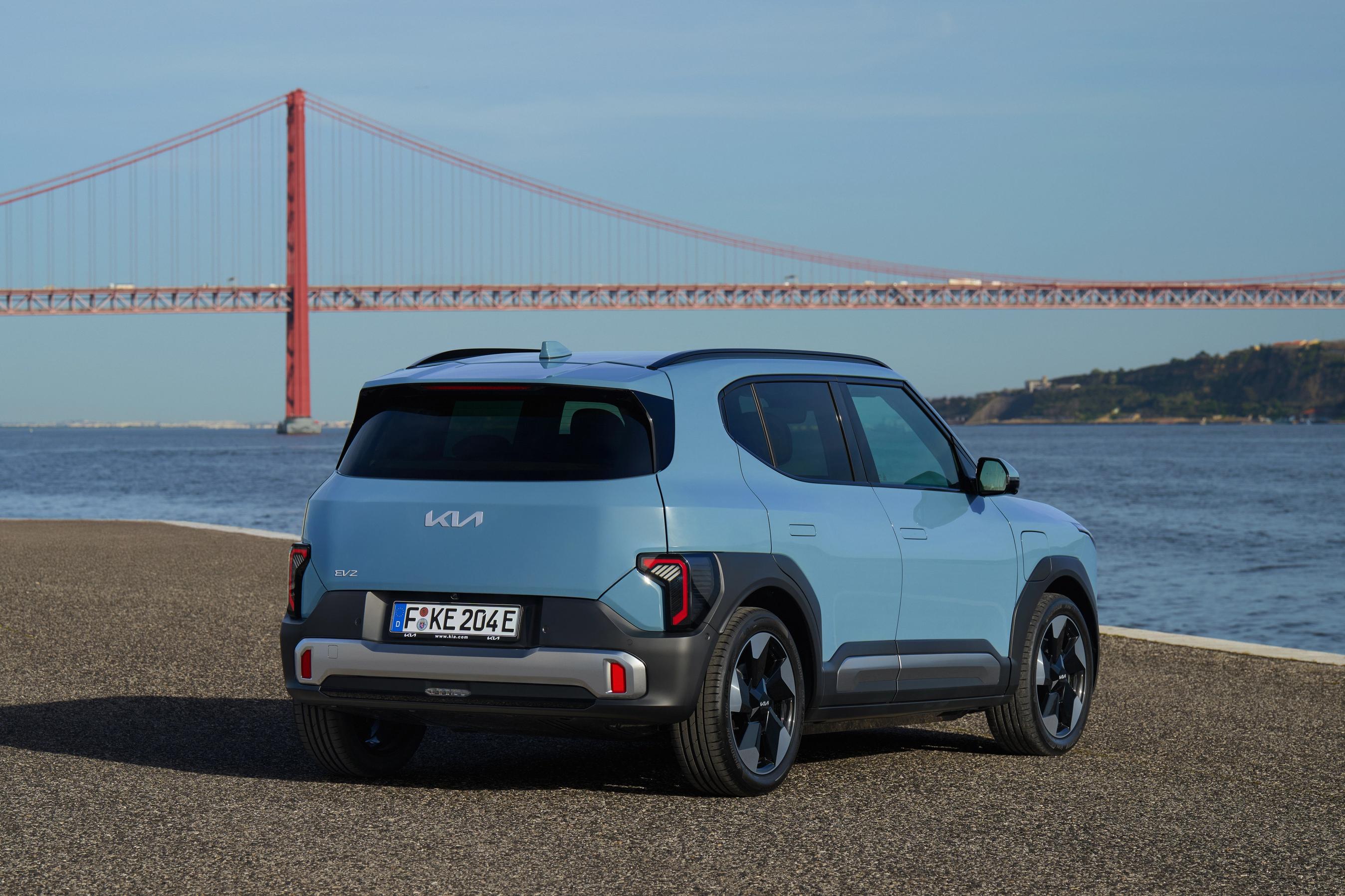 Kia EV2 set bagfra, mens den holder med bro og hav i baggrunden