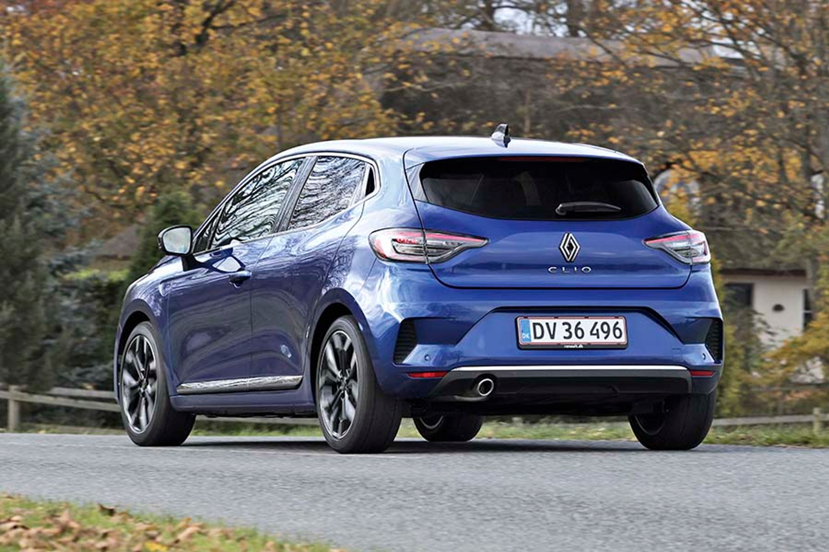 Blå Renault Clio set bagfra, mens den holder foran bondegård