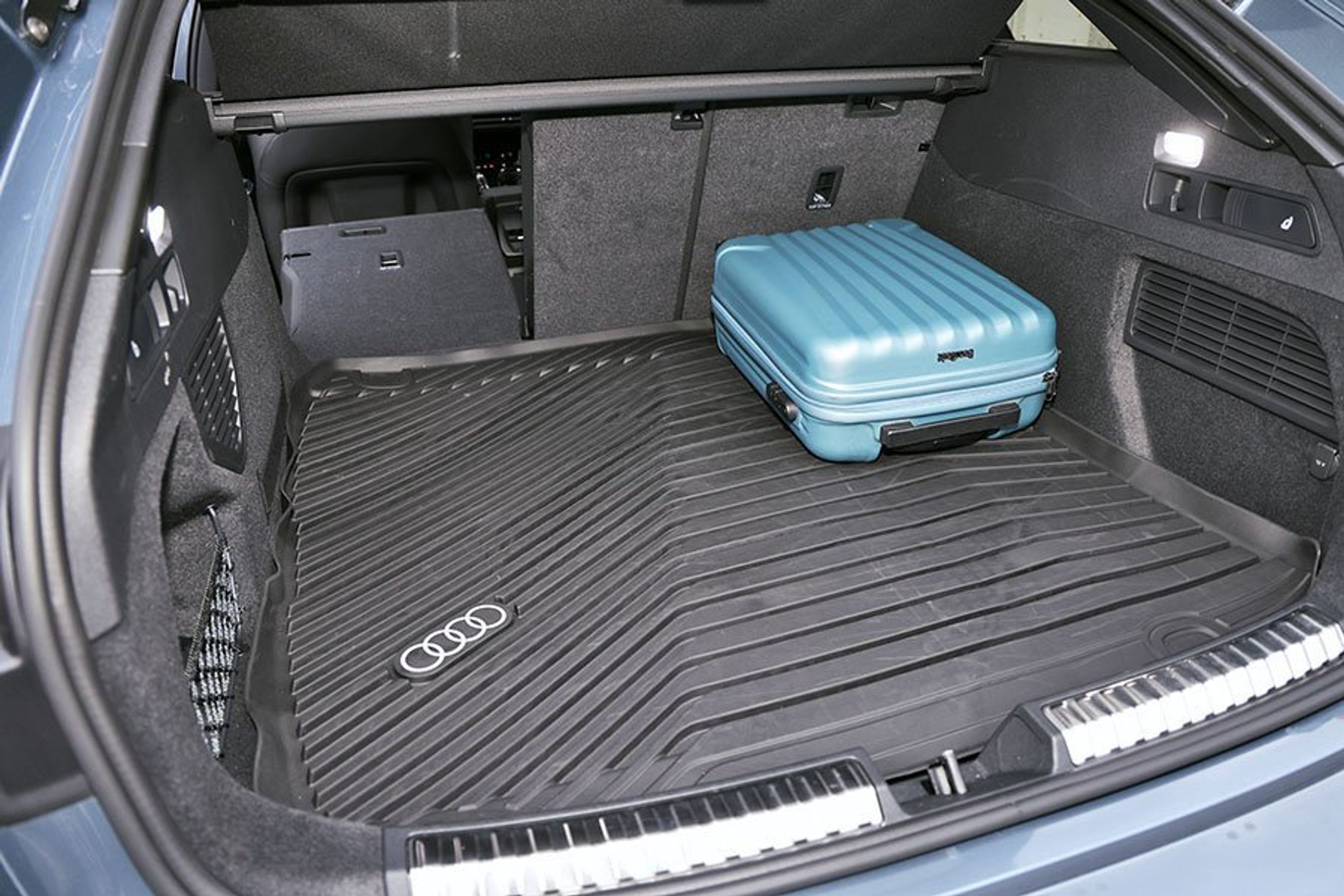Bagagerum med en blå kuffert i en Audi A5 Avant