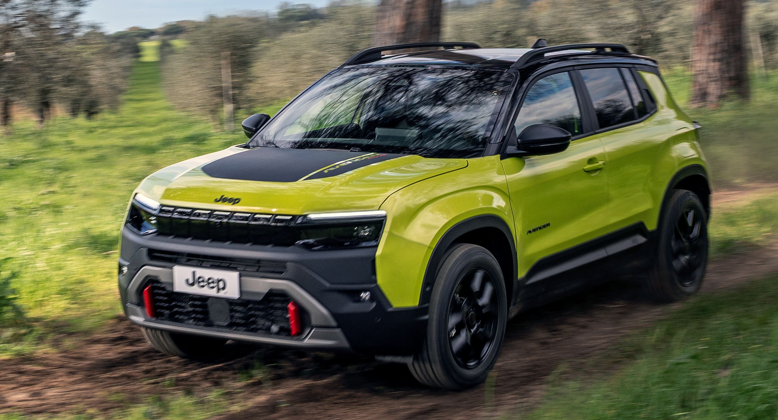 Grønlig Jeep Avenger skråt forfra i terræn.