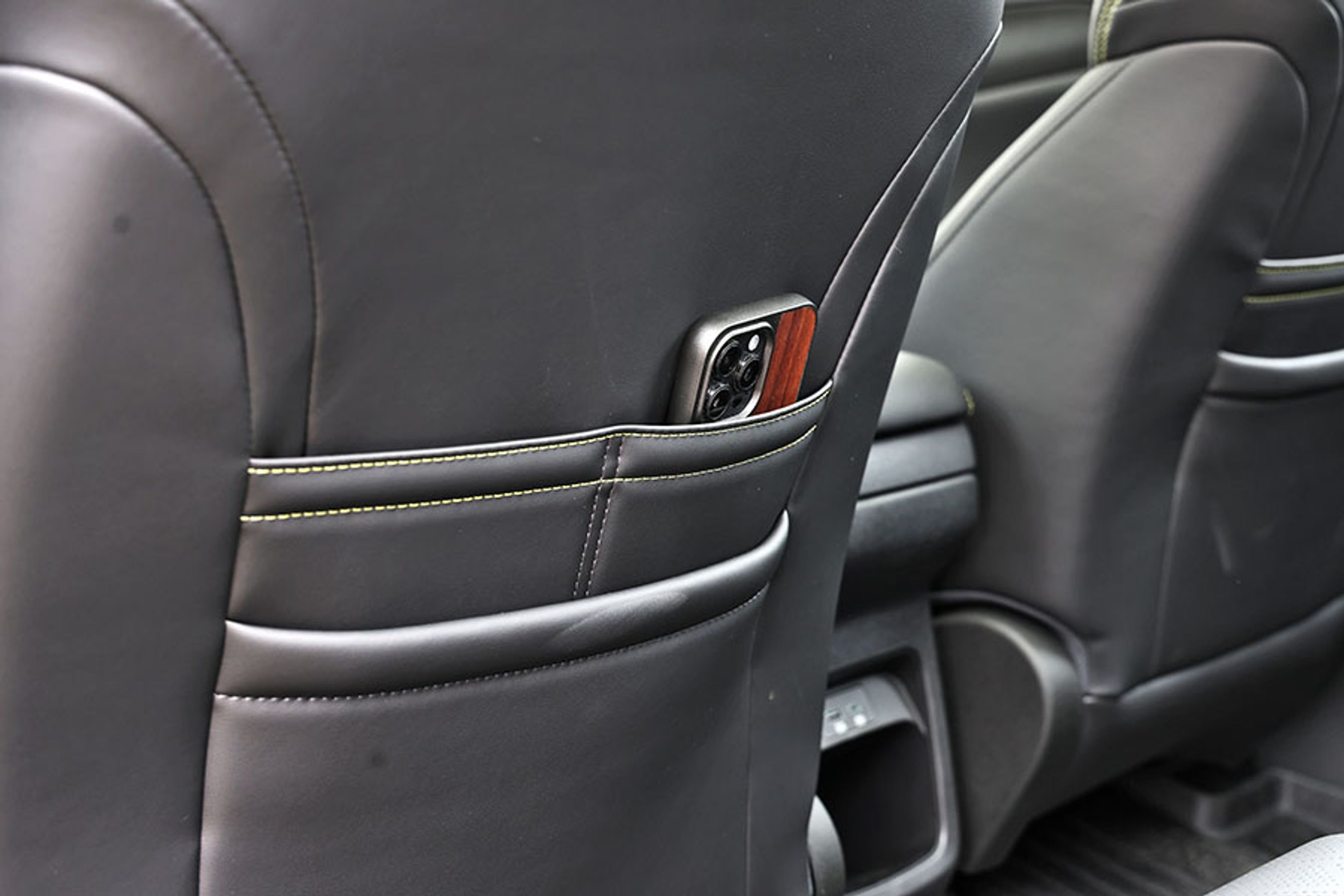 En lomme bag forsæderne gør det let at holde styr på f.eks. mobiltelefonen. Mellem forsæderne er der stik til opladning.