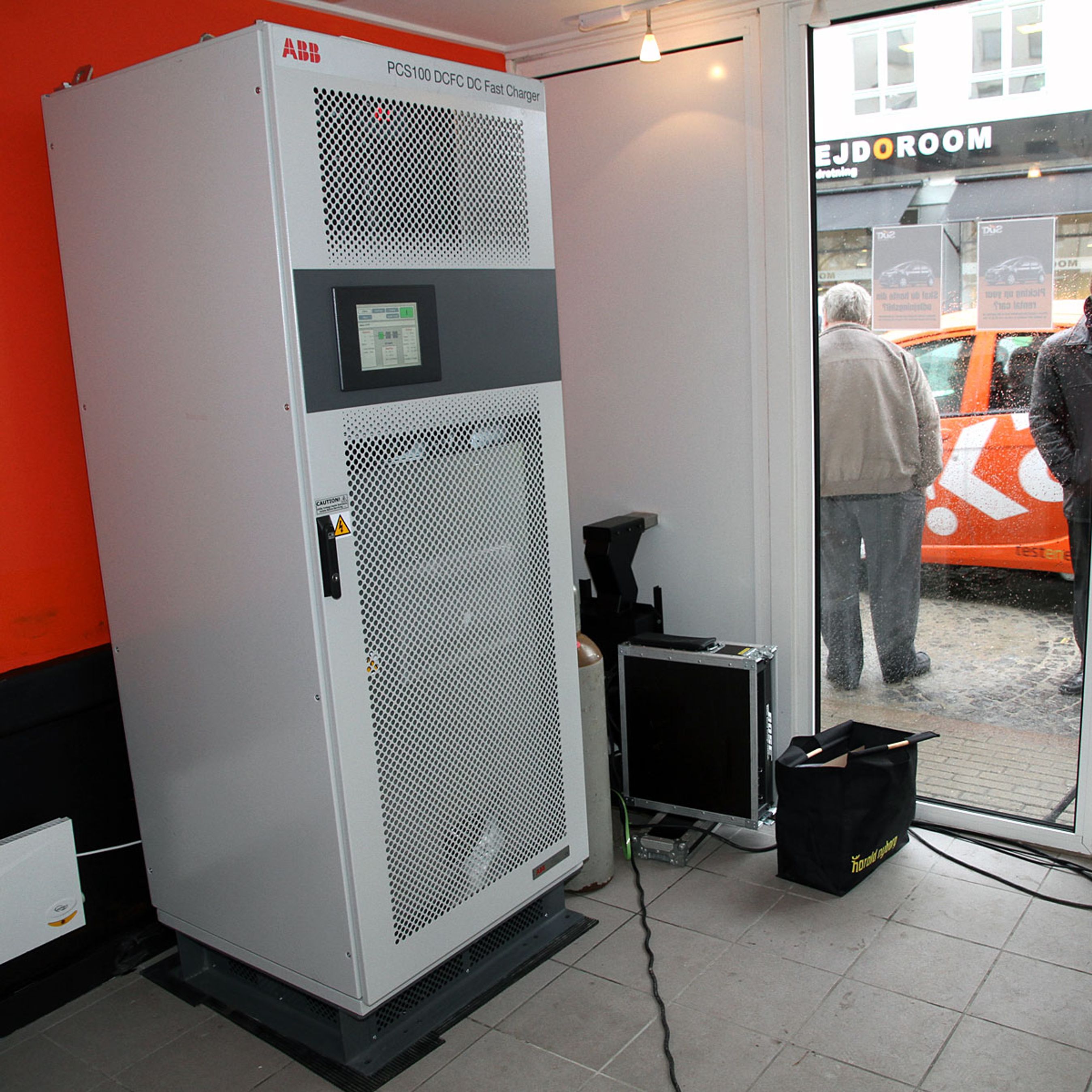 Ladestanderen i bybilledet er blot en tom skal med betjeningspanel. Selve laderen står i et separat lokale og er på størrelse med et amerikanerkøleskab. Produktionsmodellen bliver dog noget mindre, siger producenten ABB.