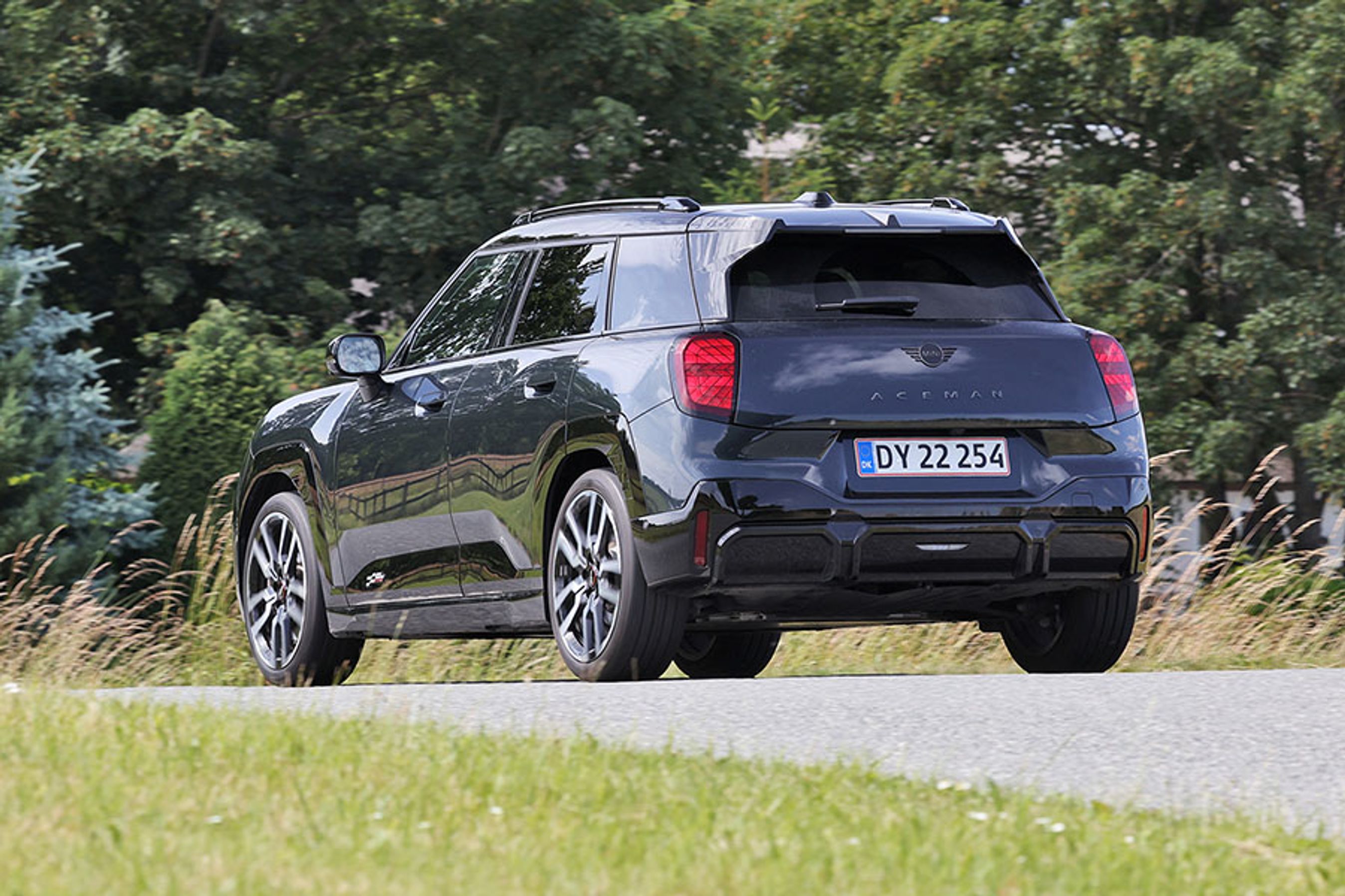 Mini Aceman set bagfra, mens den kører på landevej med træer i baggrunden