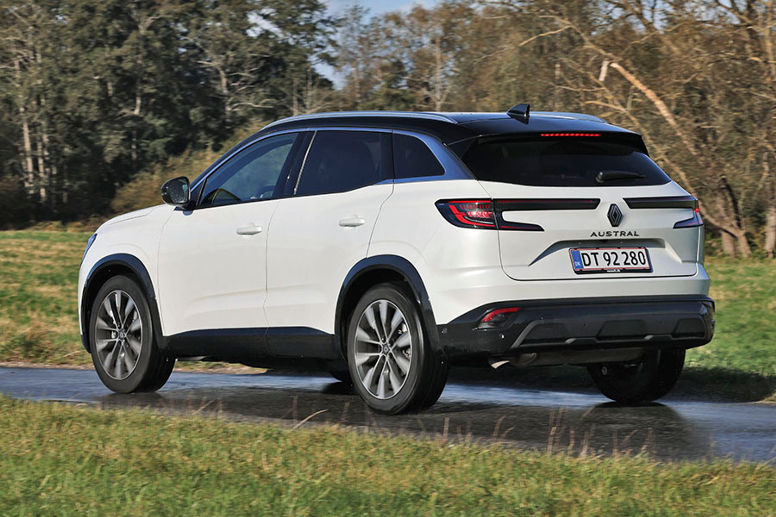 En hvid Renault Austral set bagfra, mens den kører på en våd vej