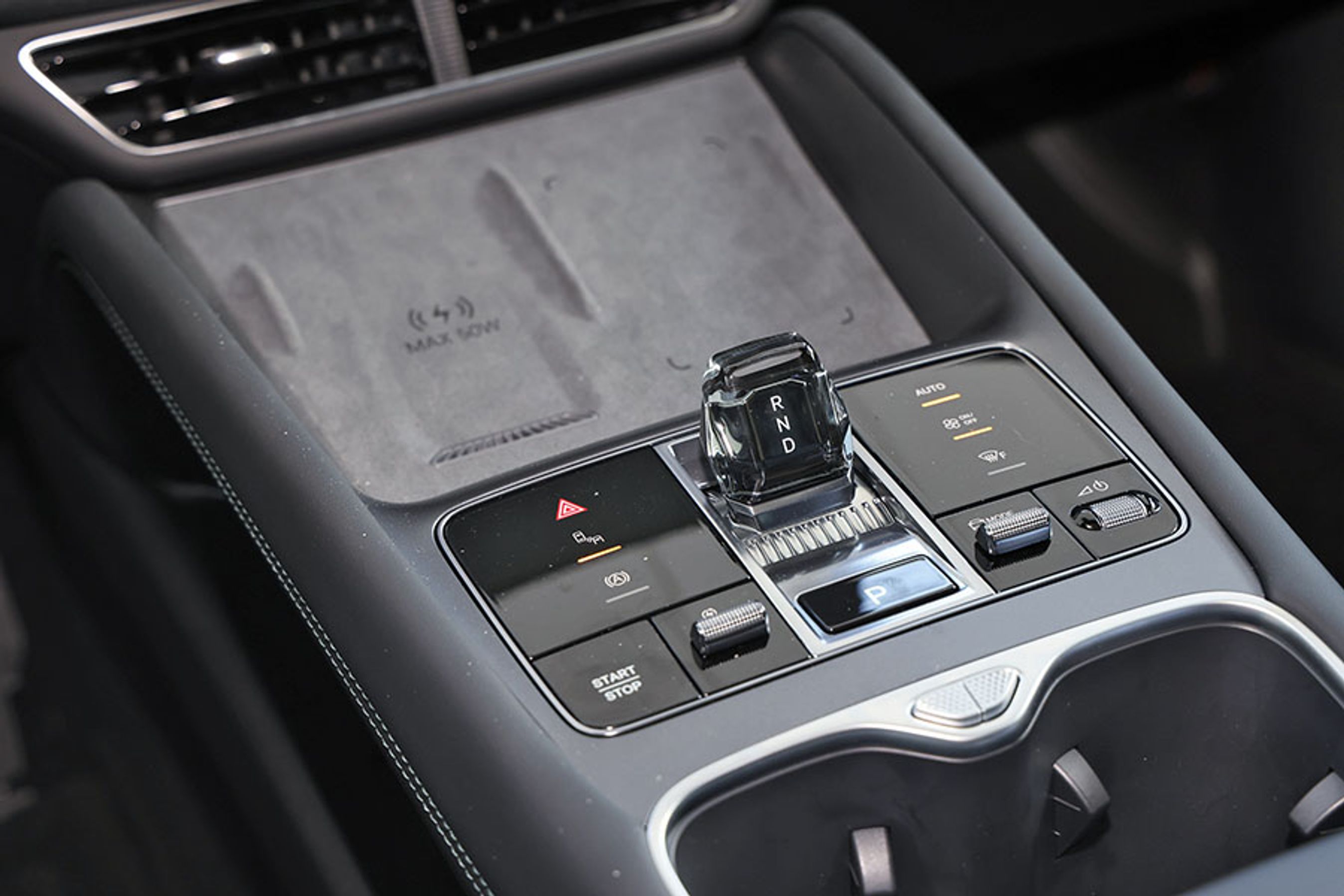 Den lille gennemsigtige gearvælger er nem at betjene. Bag den finder du en trådløs lader til mobilen, der kan supplere med hele 50 watt. Der er også en meget effektiv køling, så telefonen bliver kølet af under opladningen. Imponerende. 