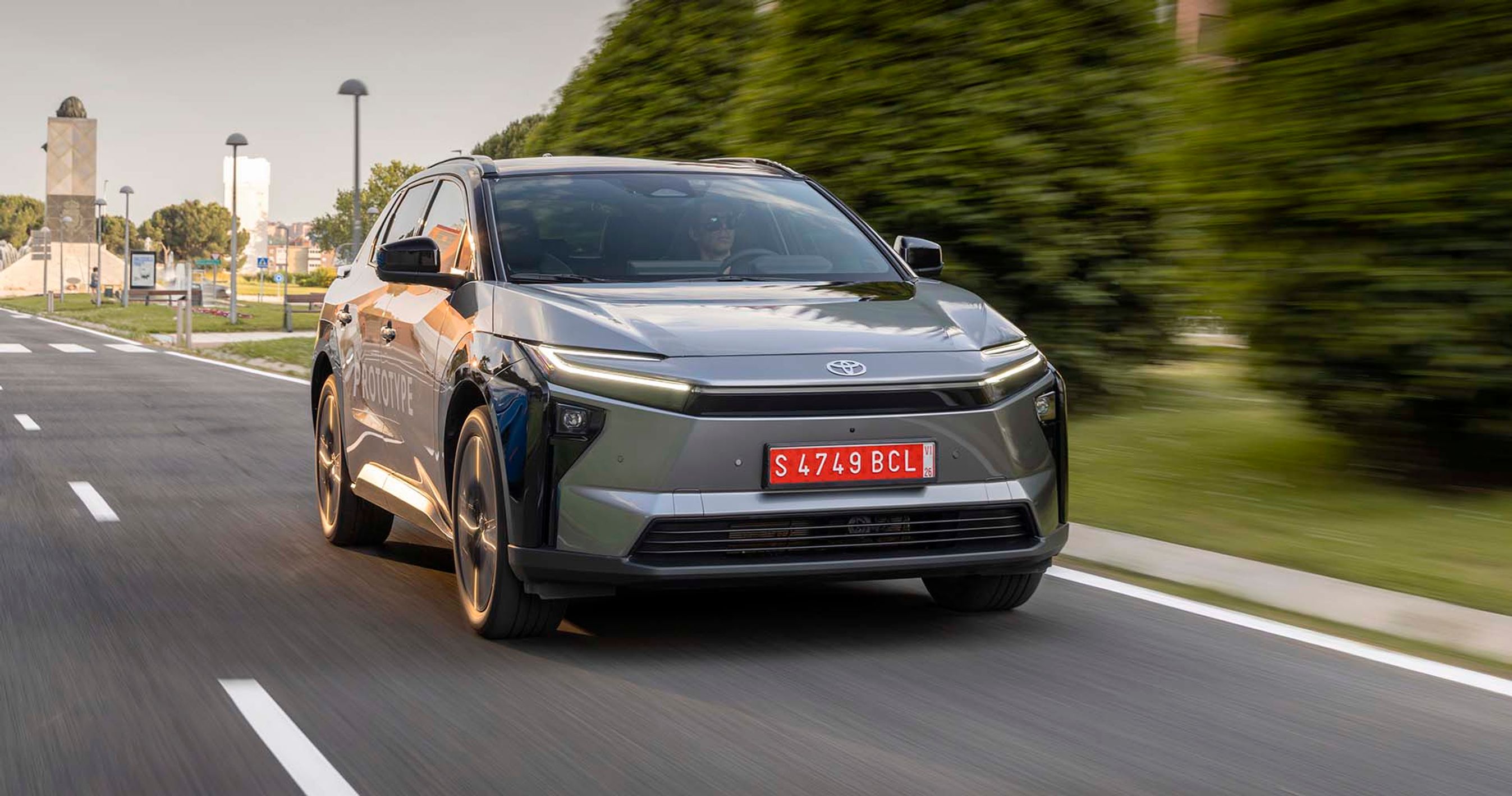 Toyota bZ4X set forfra, mens den kører ud af en by