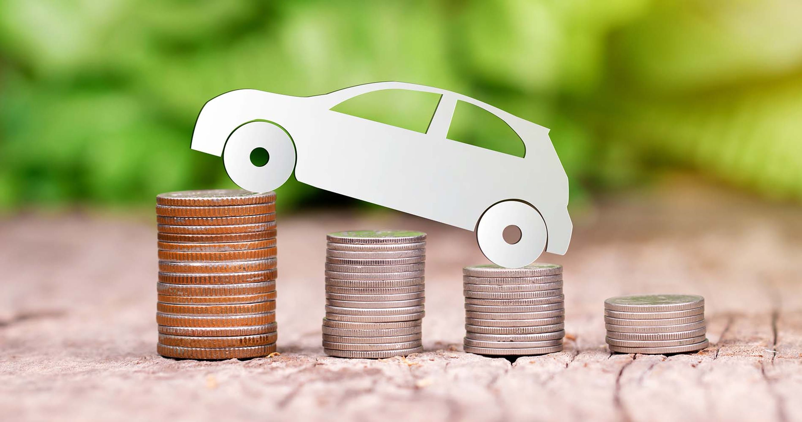 Modelbil kører op ad stabler af mønter