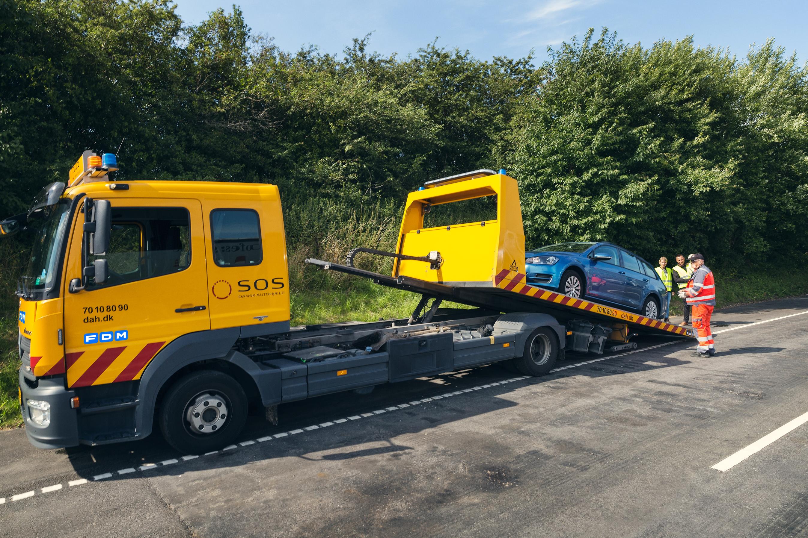 vejhjælps bil med personbil på lad