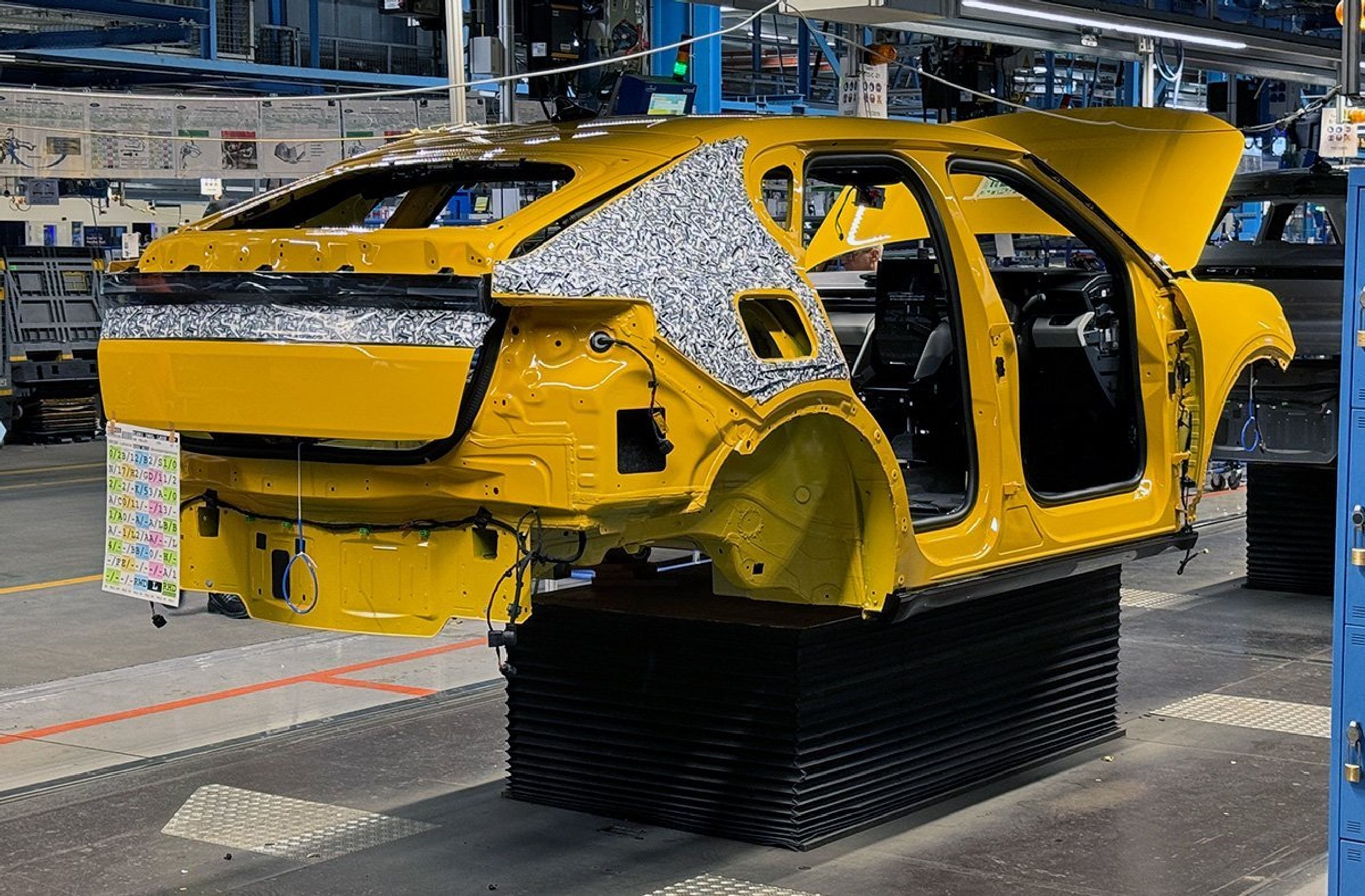 Gul bil på samlebånd.