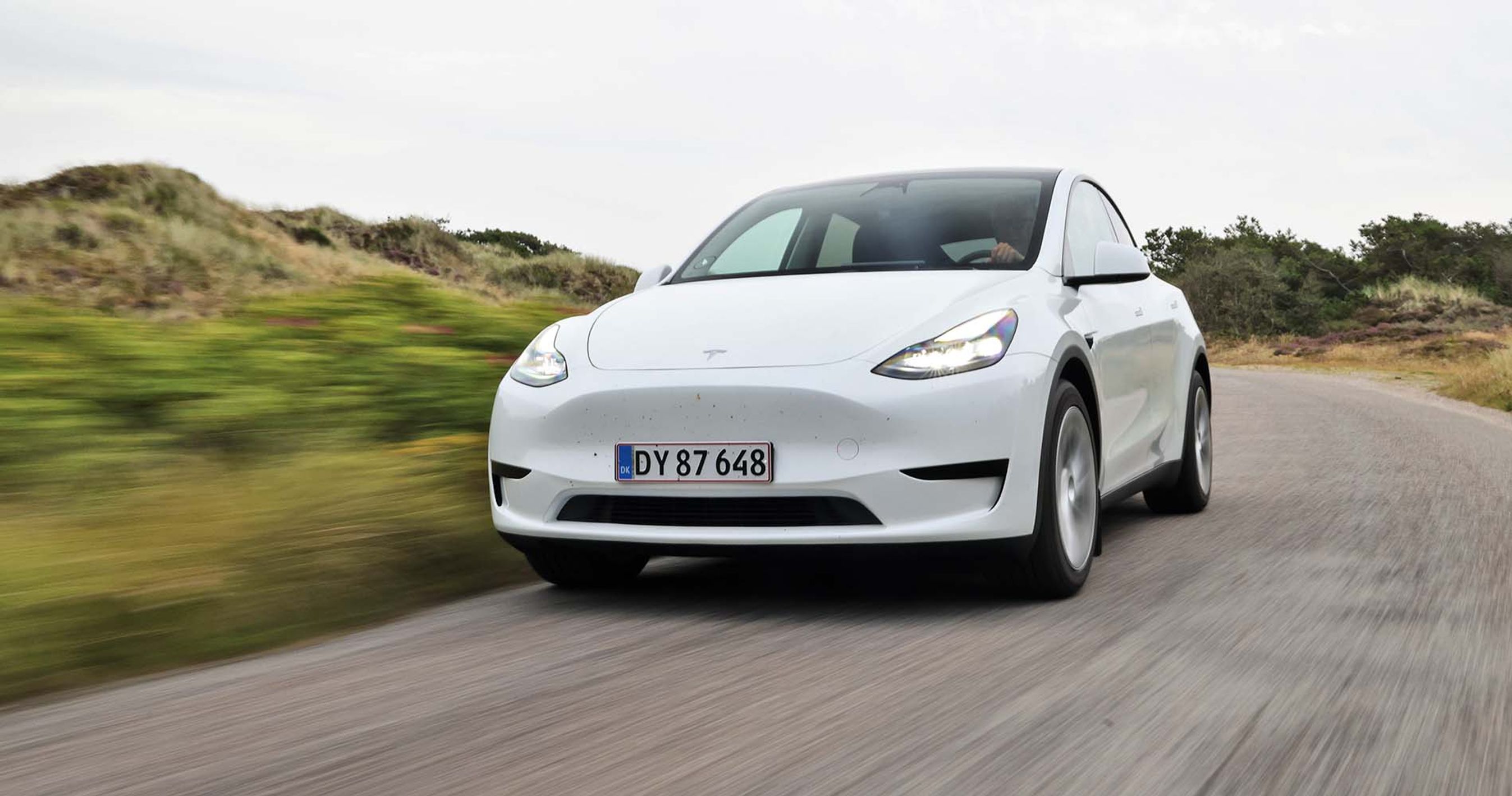 Hvid Tesla Model Y kører på landevej