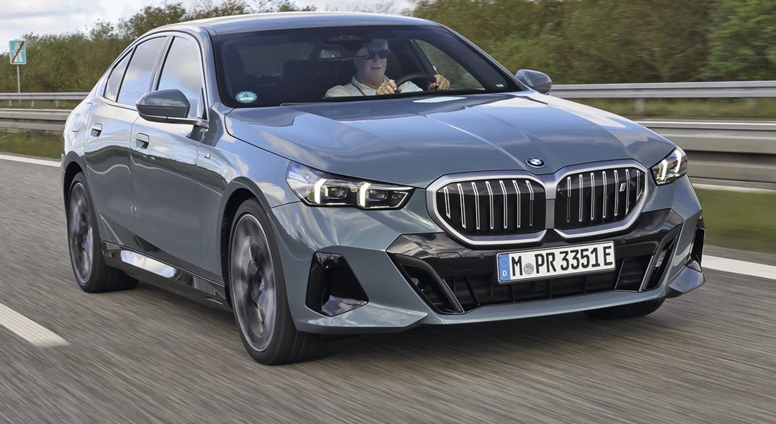 BMW i5 i fart set skråt forfra.