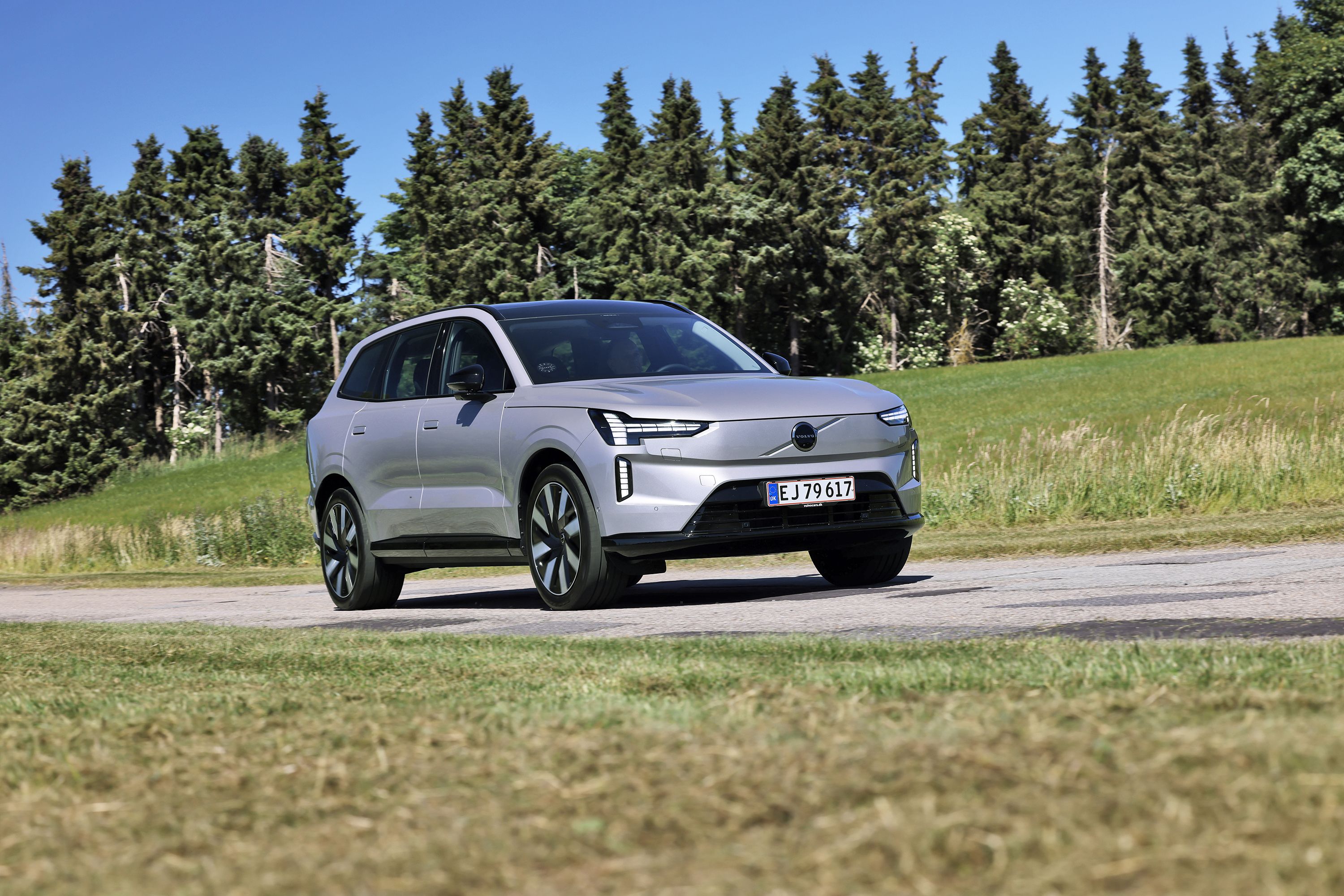 Volvo EX90 kører på landevej med træer i baggrunden