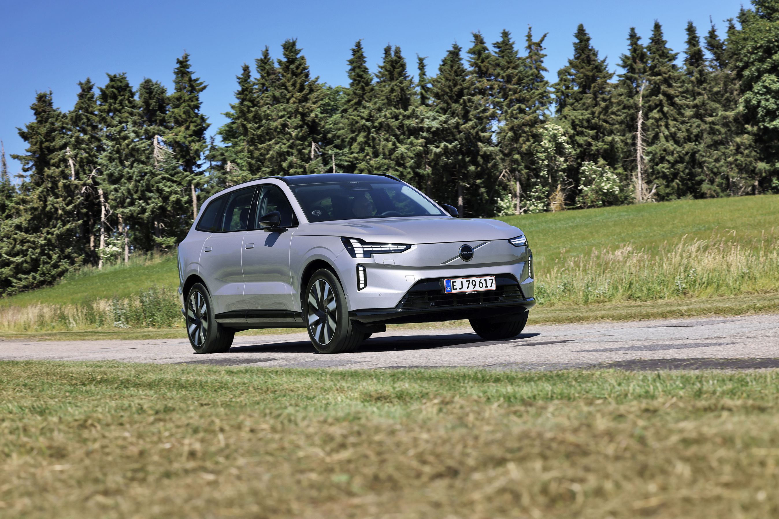 Volvo EX90 kører på landevej med træer i baggrunden