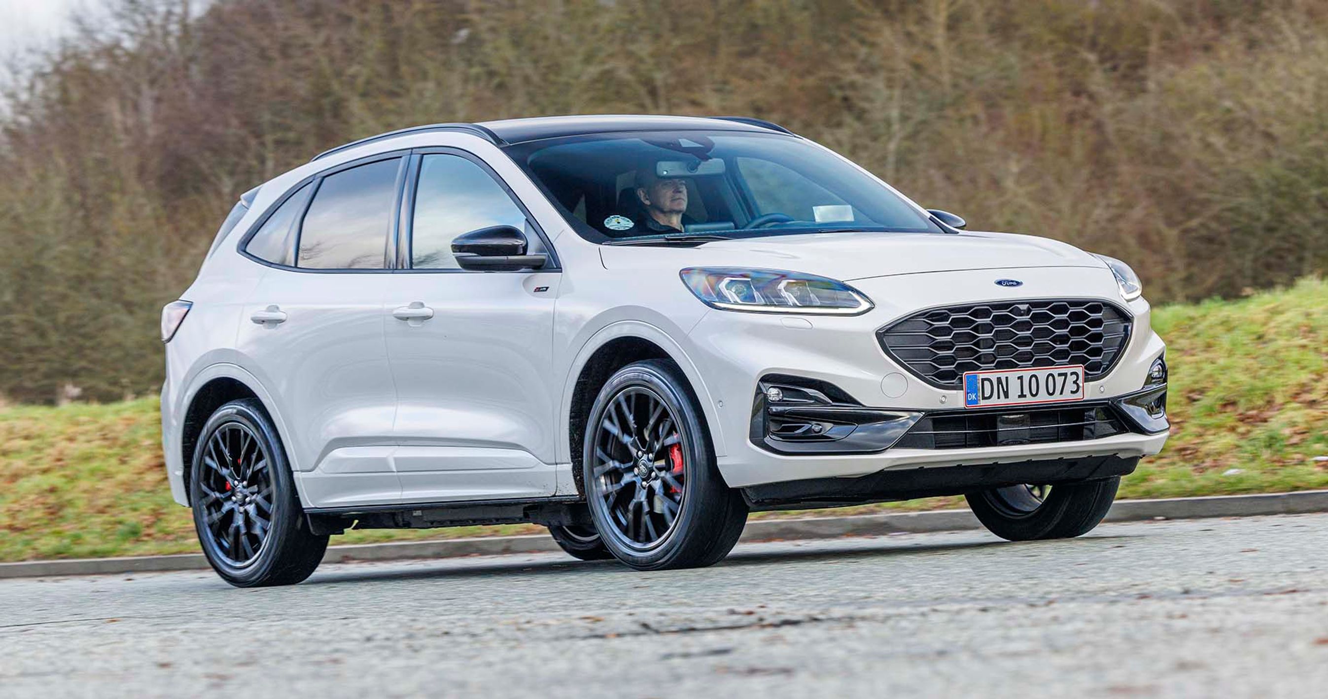 Ford Kuga kører på en landevej med træer i baggrunden