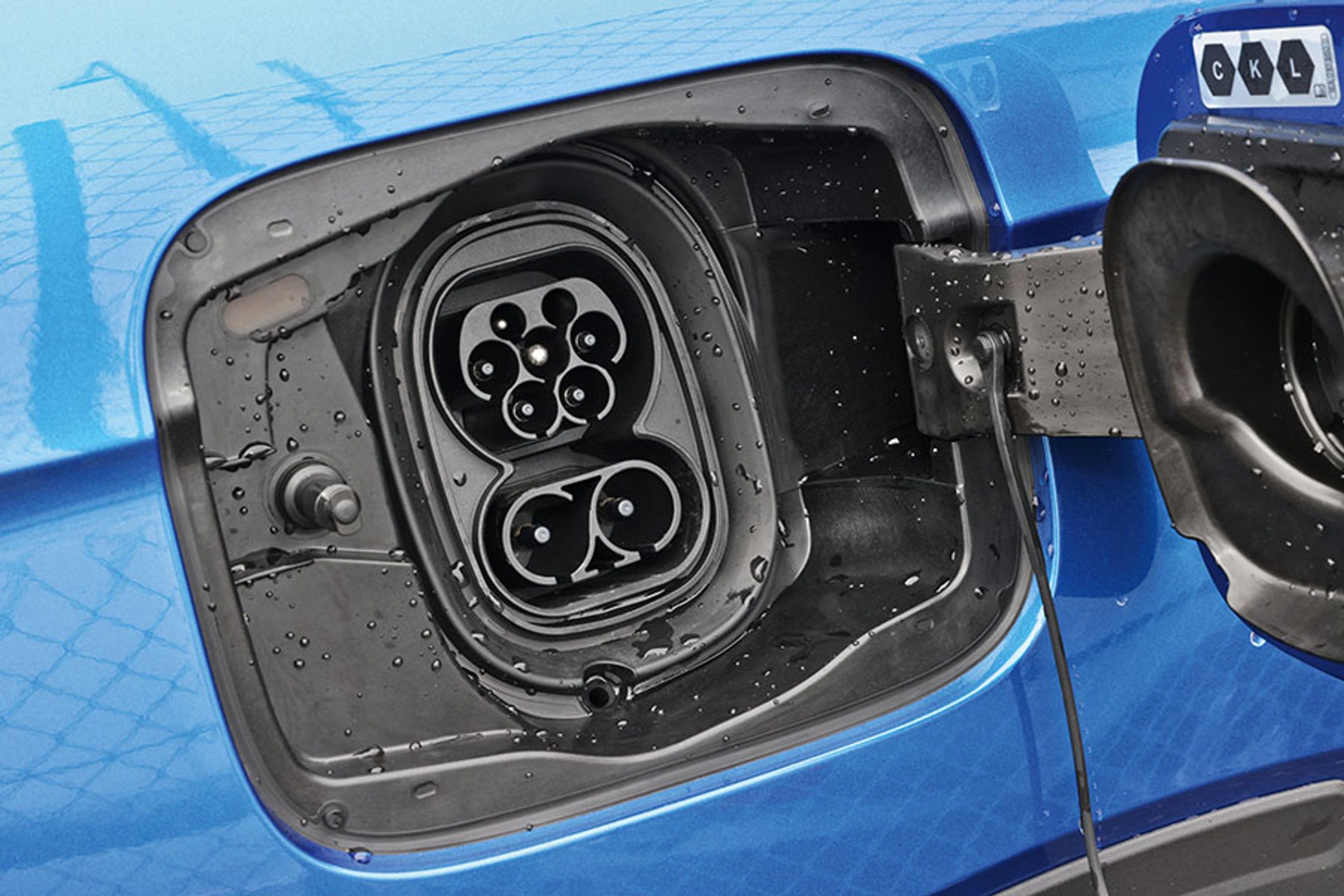 Ladeklappen er placeret ved højre baghjul. Hjemme kan bilen lades med 11 kW, og på farten kan bilen oplades med op til 165 kW. Dækslet er forsynet med en gummitætning, så man slipper for plasticpropper i de to stik.