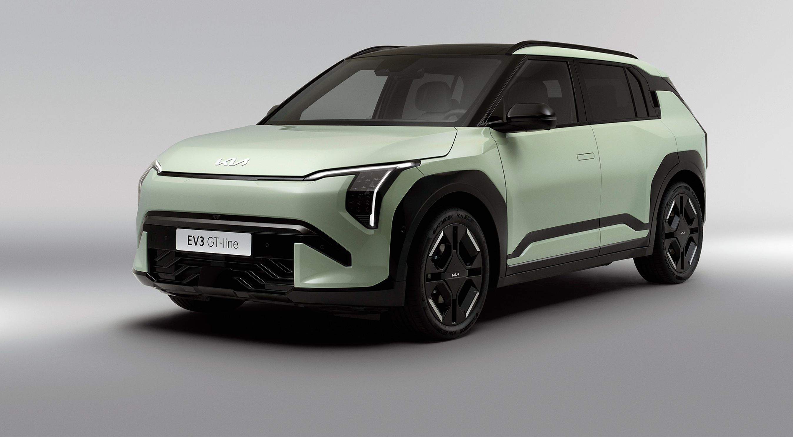 Lysegrøn Kia EV3 i studie skråt forfra.