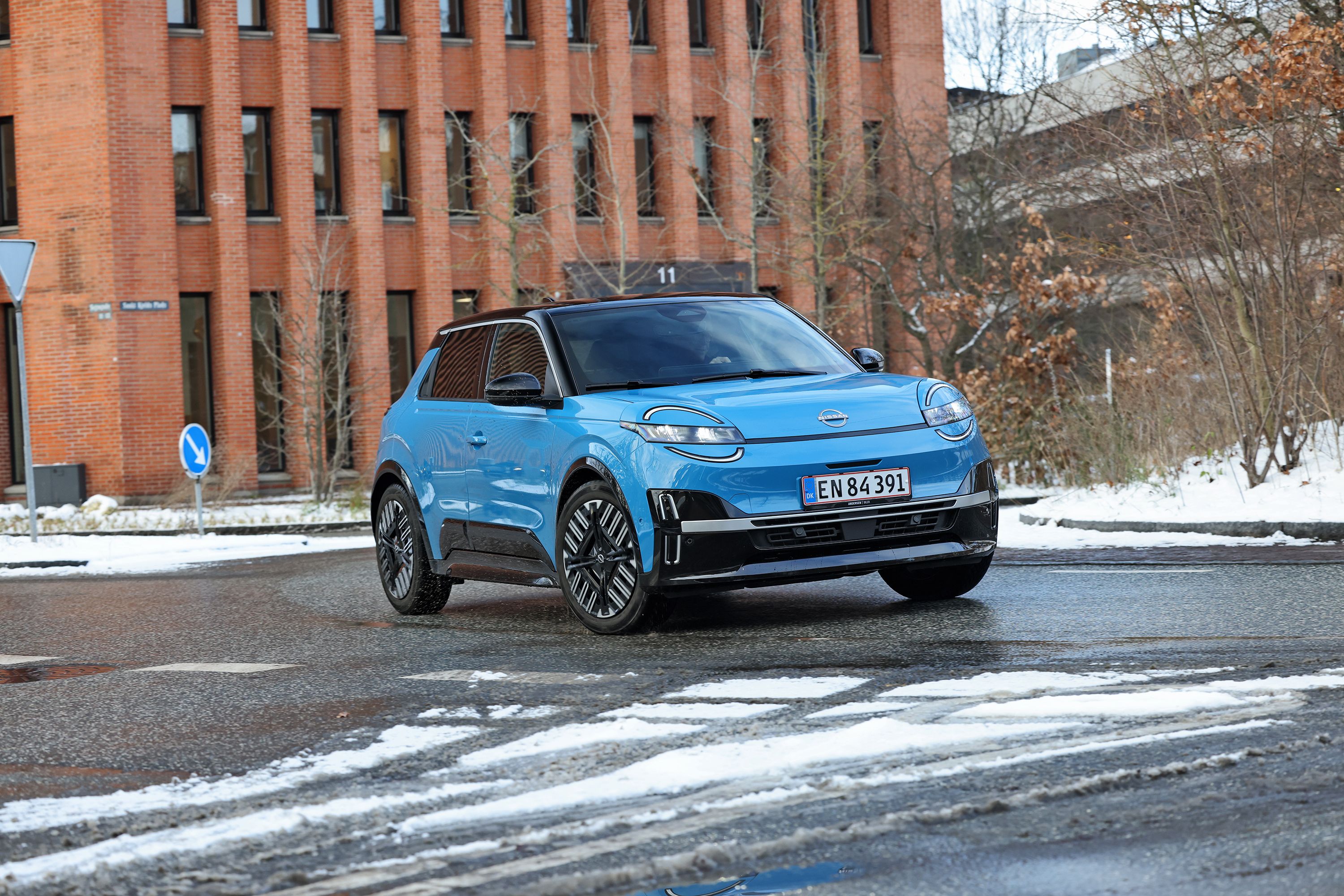 Blå Nissan Micra set forfra, mens den kører i en rundkørsel