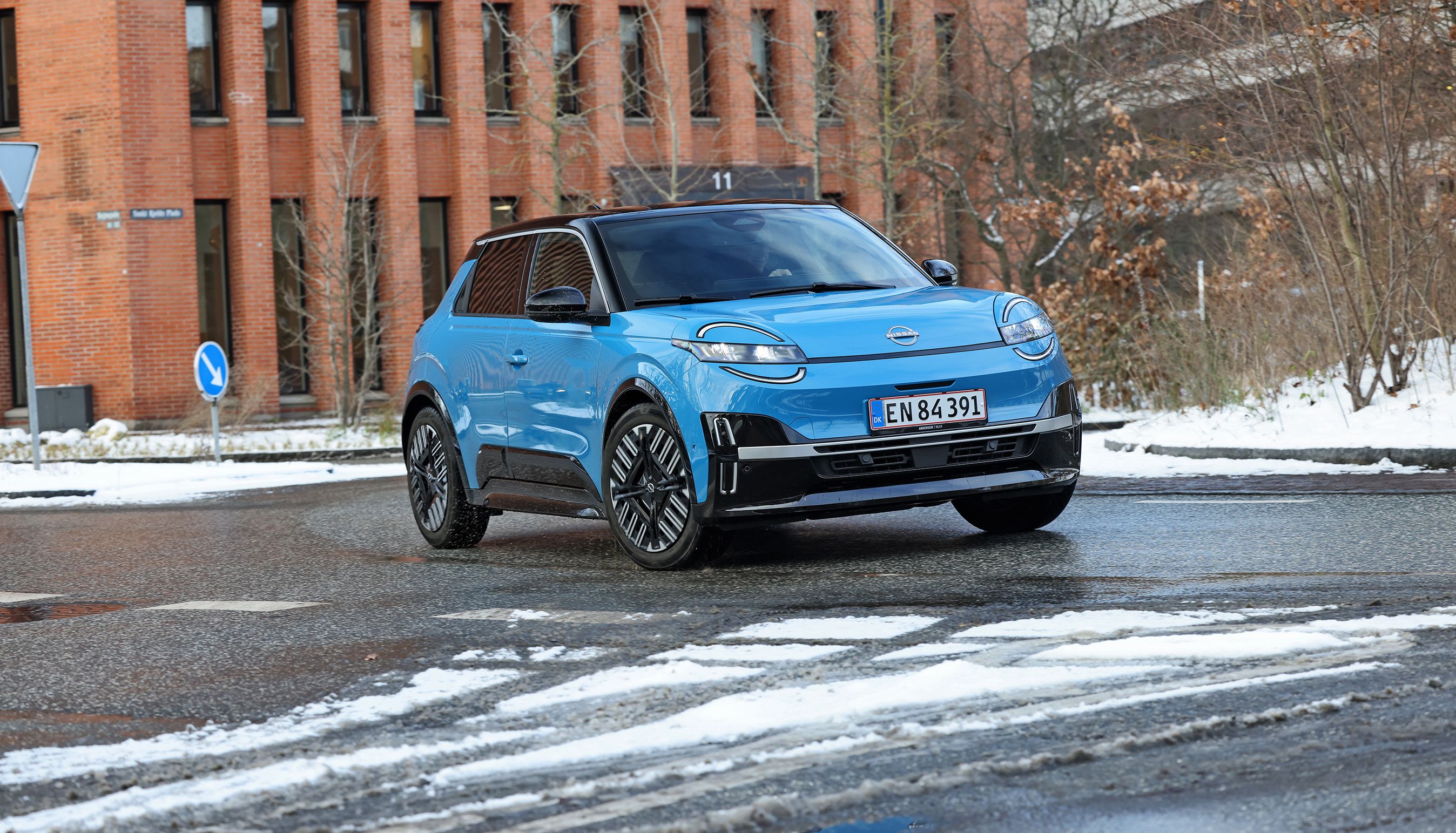 Blå Nissan Micra set forfra, mens den kører i en rundkørsel