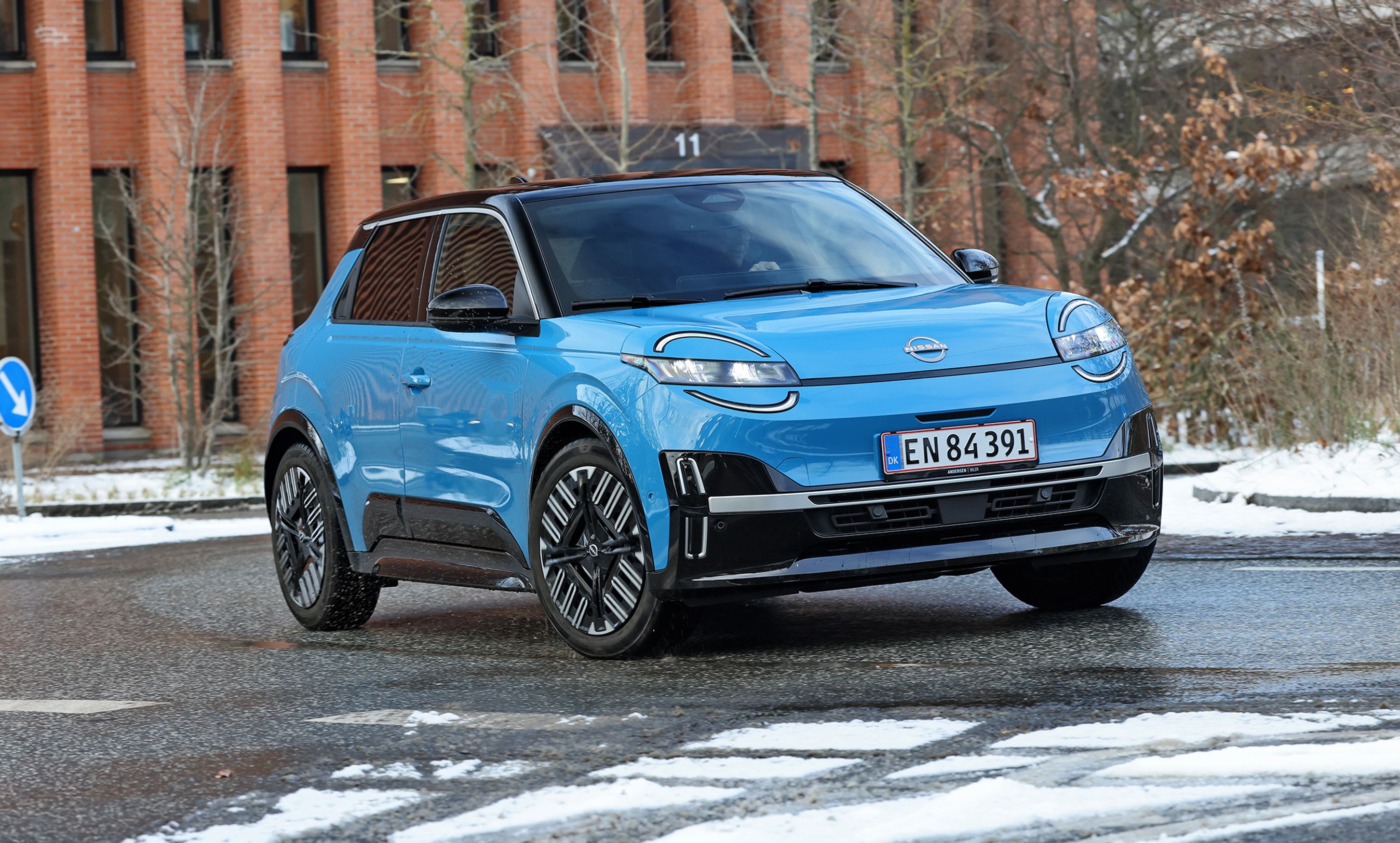 Blå Nissan Micra set forfra, mens den kører i en rundkørsel