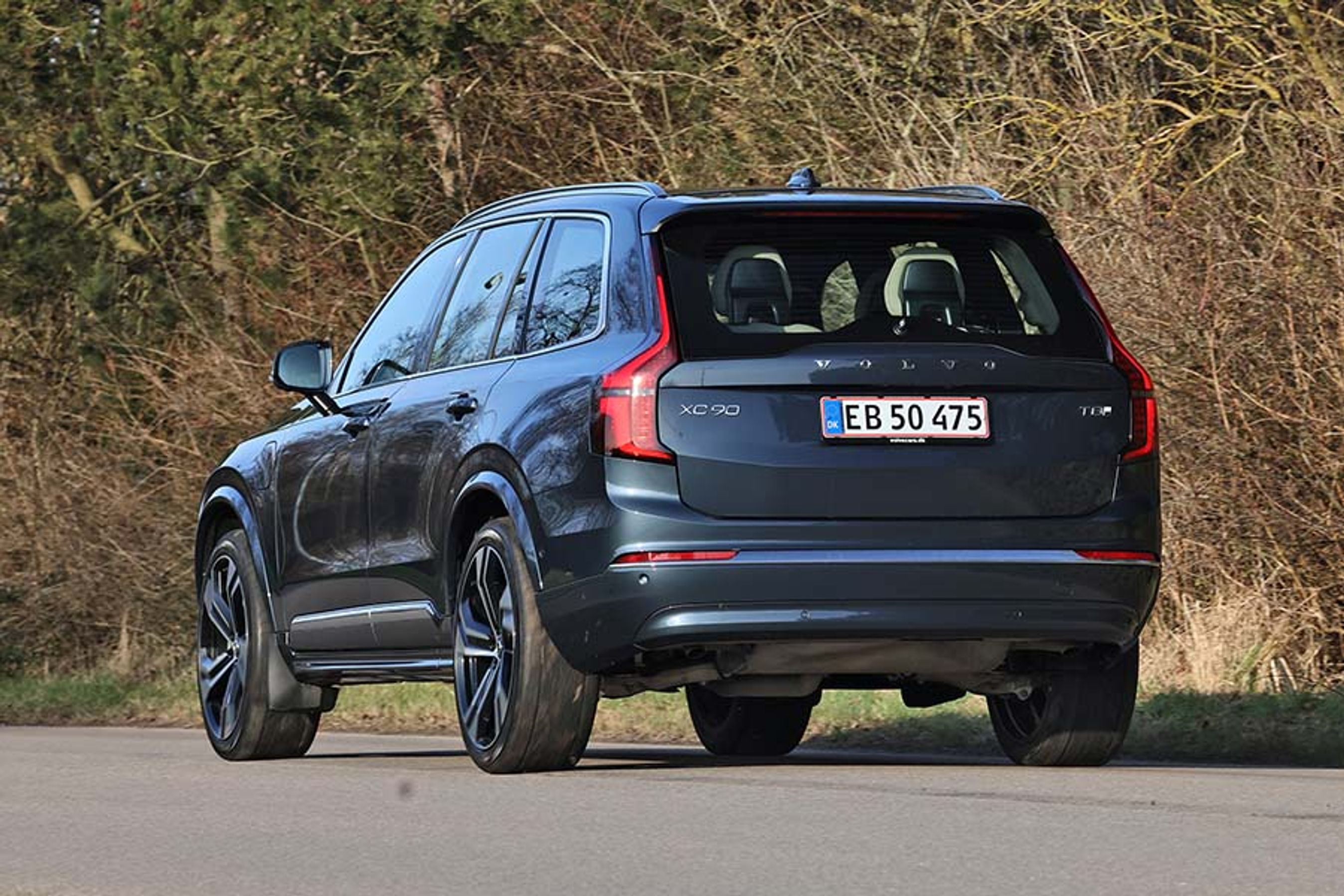 Volvo XC90 set bagfra kører på landevej med buske i baggrunden