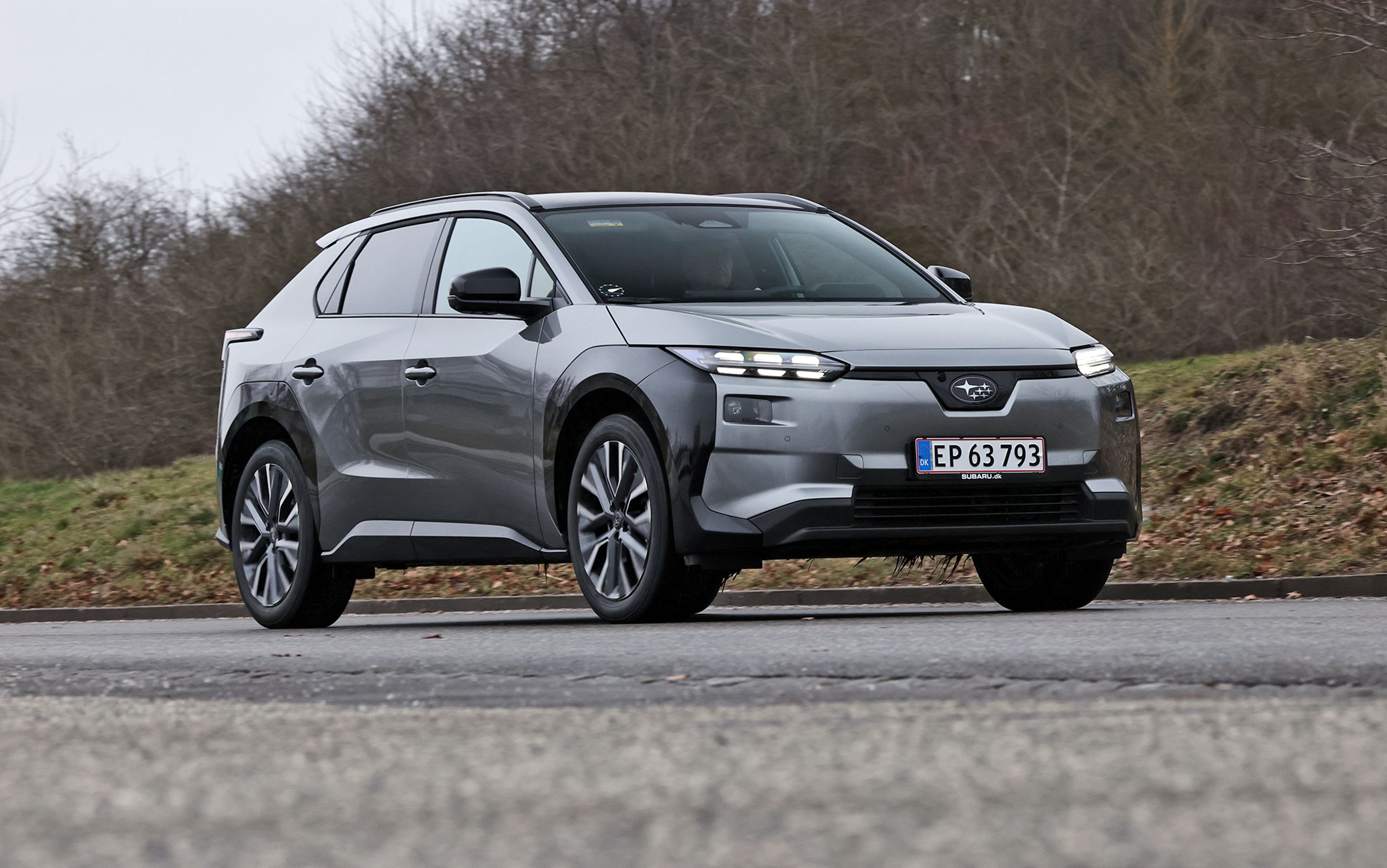 Subaru Solterra set skråt forfra, mens den holder på asfaltvej