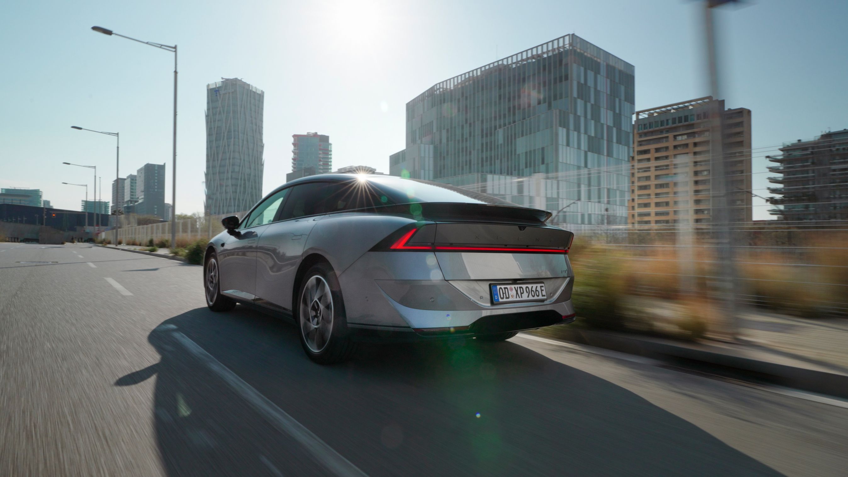 Xpeng P7+ set bagfra, mens den kører gennem moderne by.