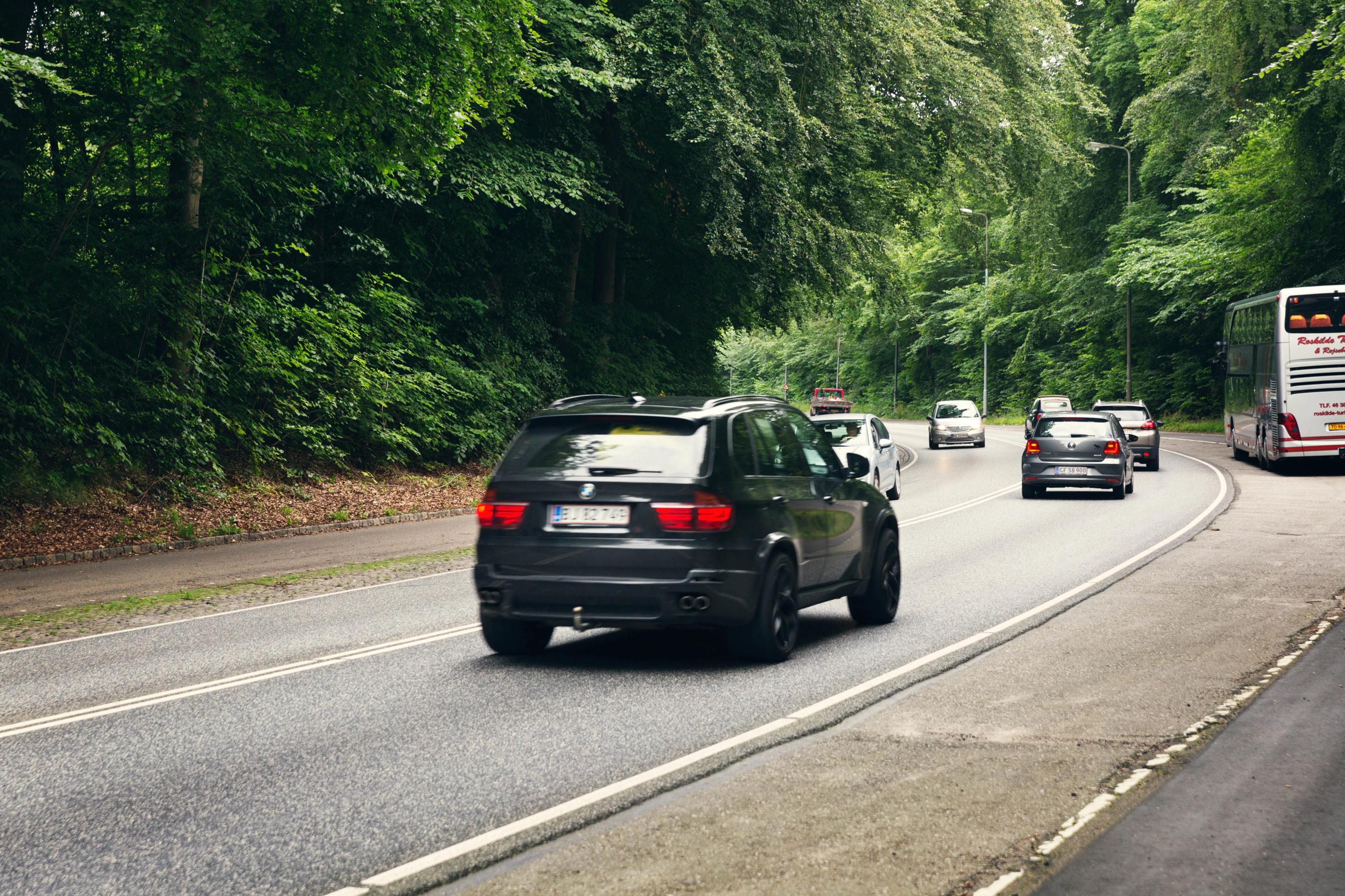 Bil kører på vej om sommeren.