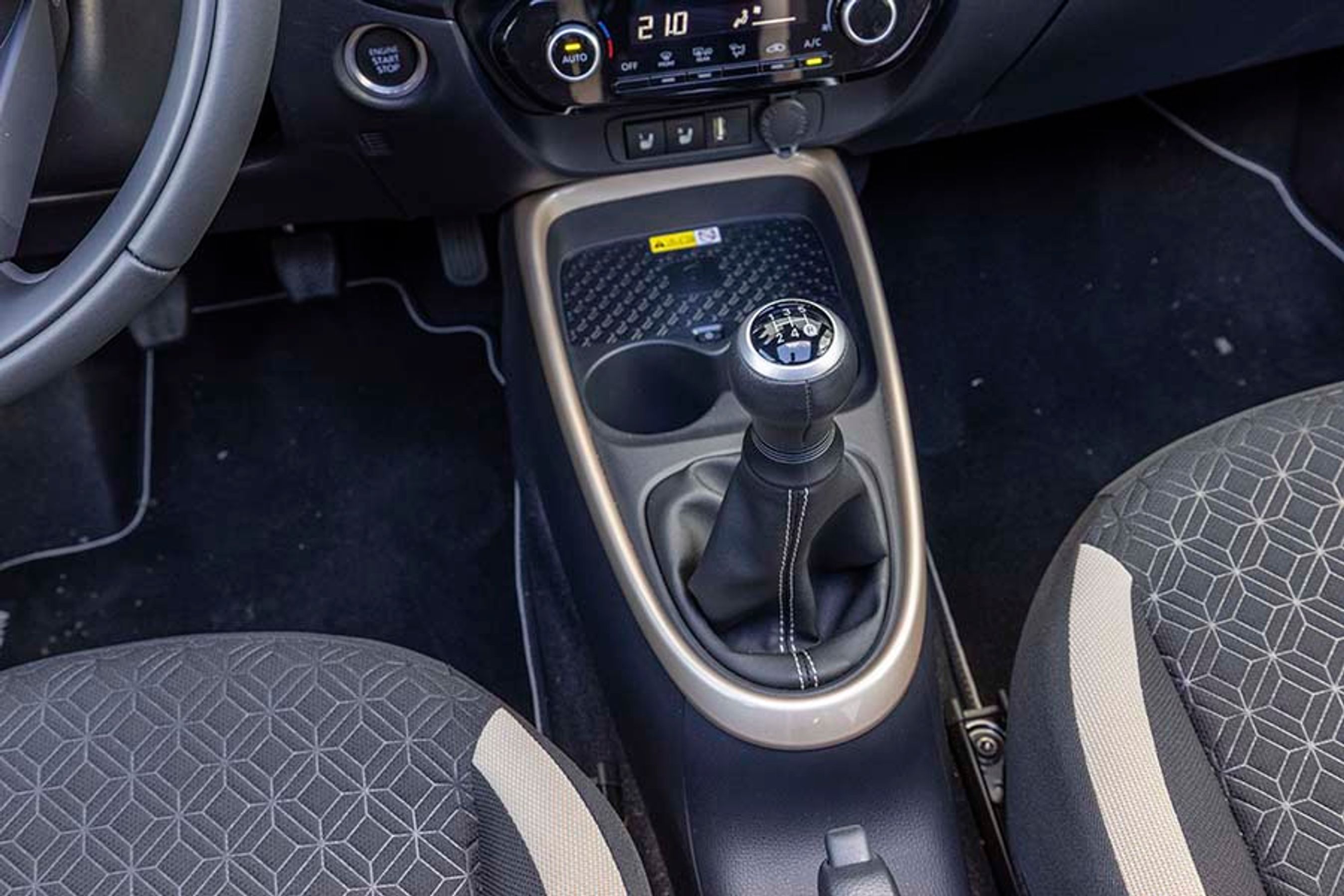 Gearkassen er manuelt betjent, og der er fem gear. Foran gearstangen er der kopholdere samt plads til trådløs opladning af mobiltelefonen.