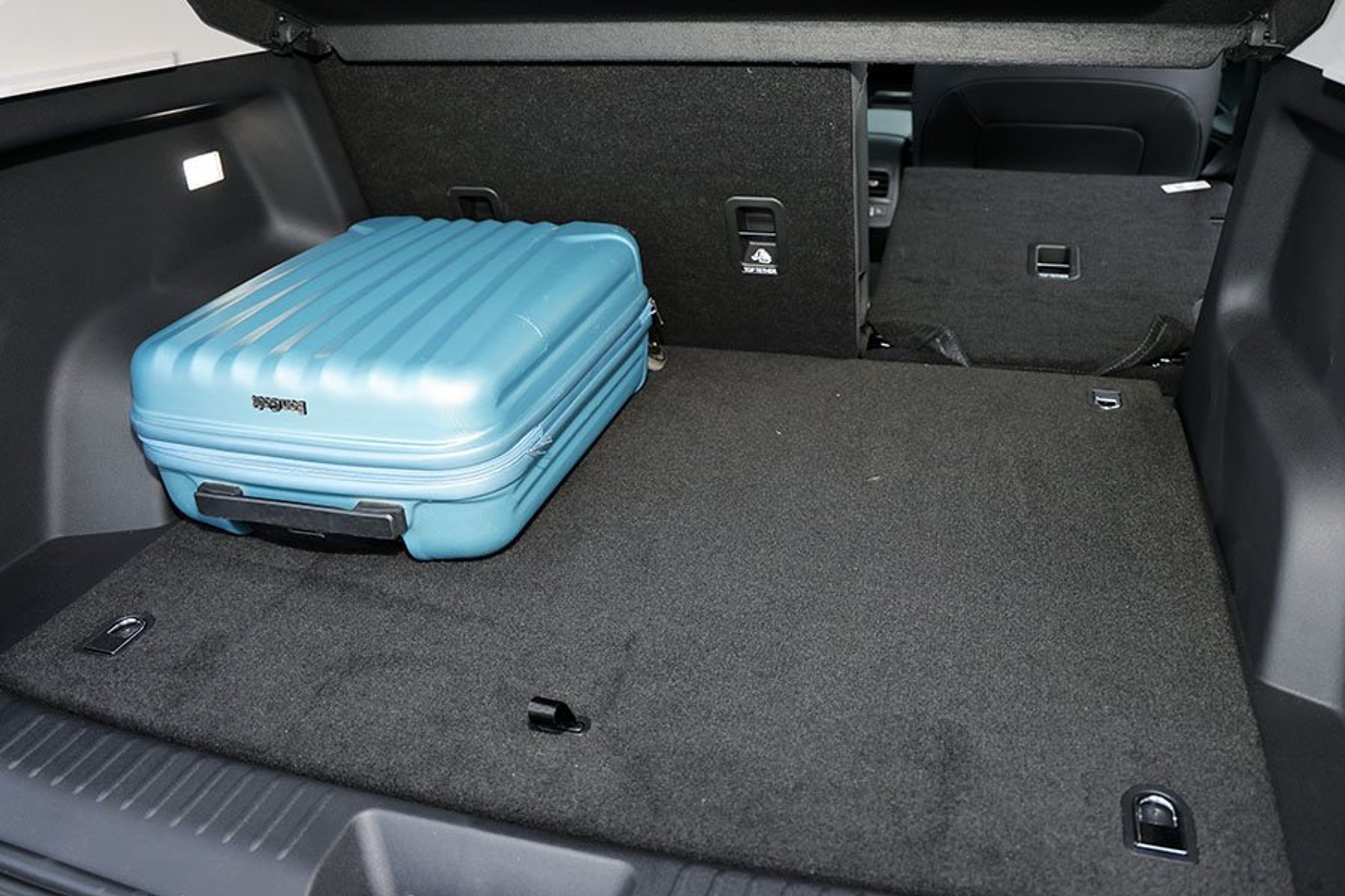 Bagagerum med blå kuffert i en Omoda 5