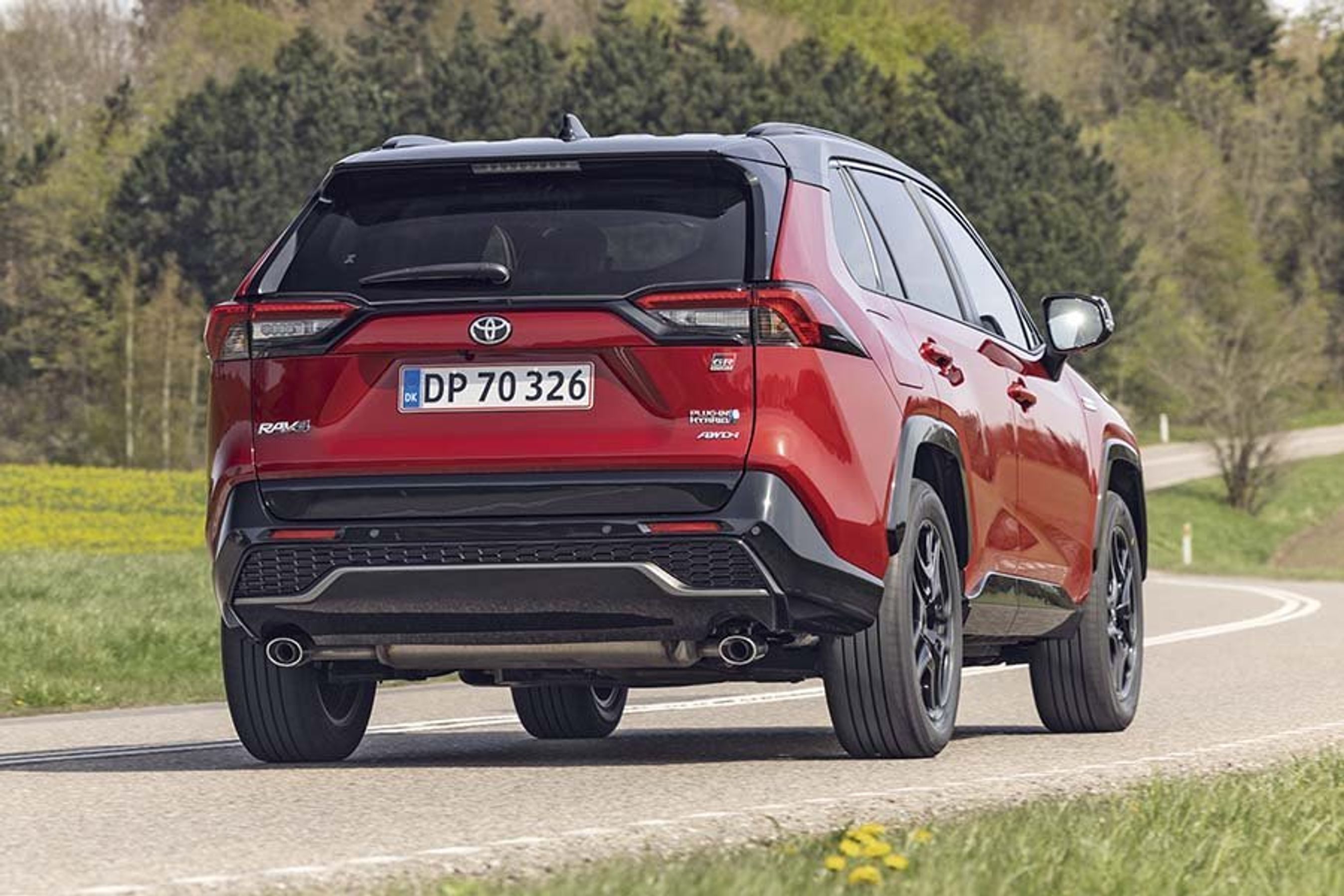 Rød Toyota RAV4 kører på landevej