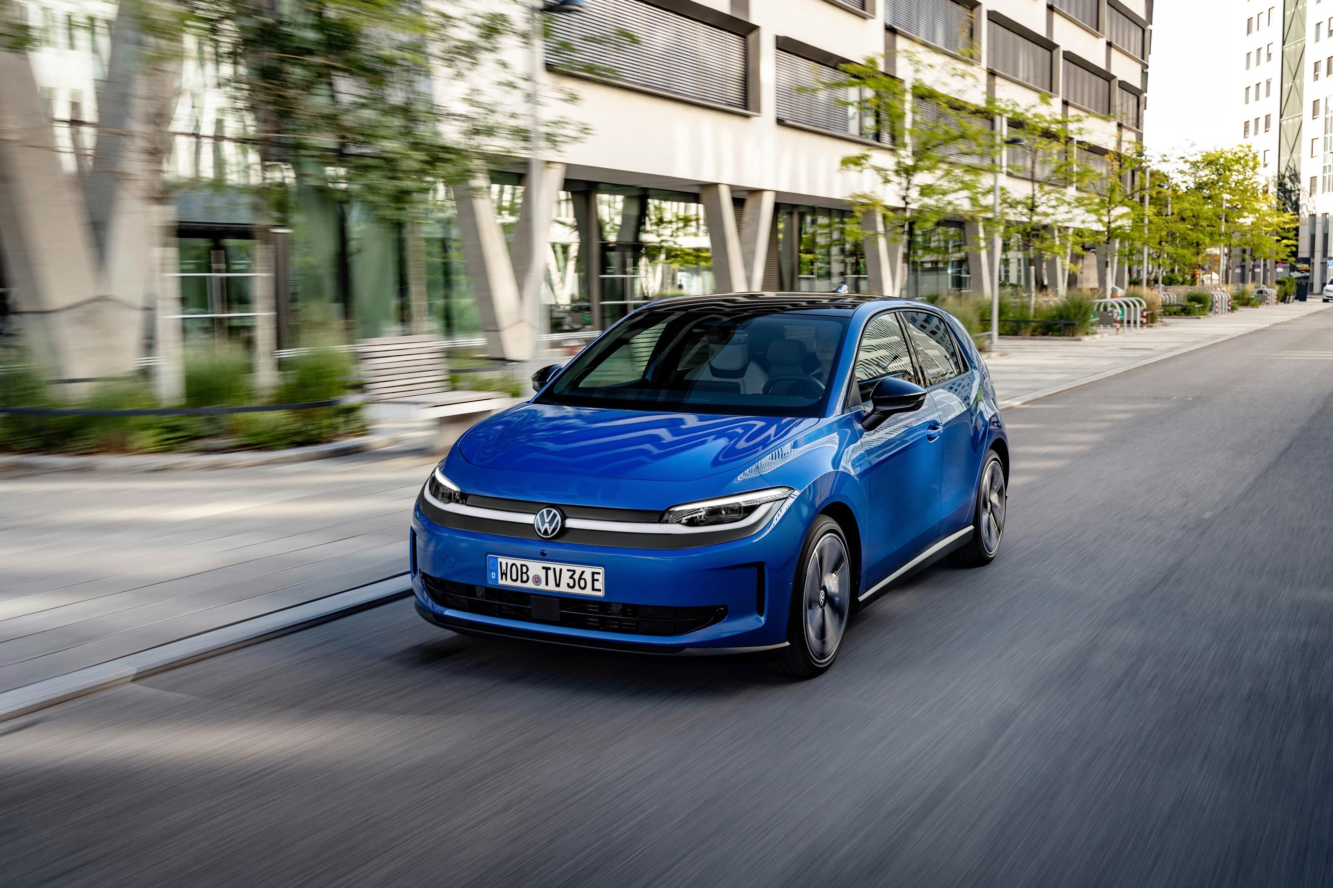 Kørebillede af Volkswagen ID. Polo 2026 i blå på vej med bygninger i baggrunden.
