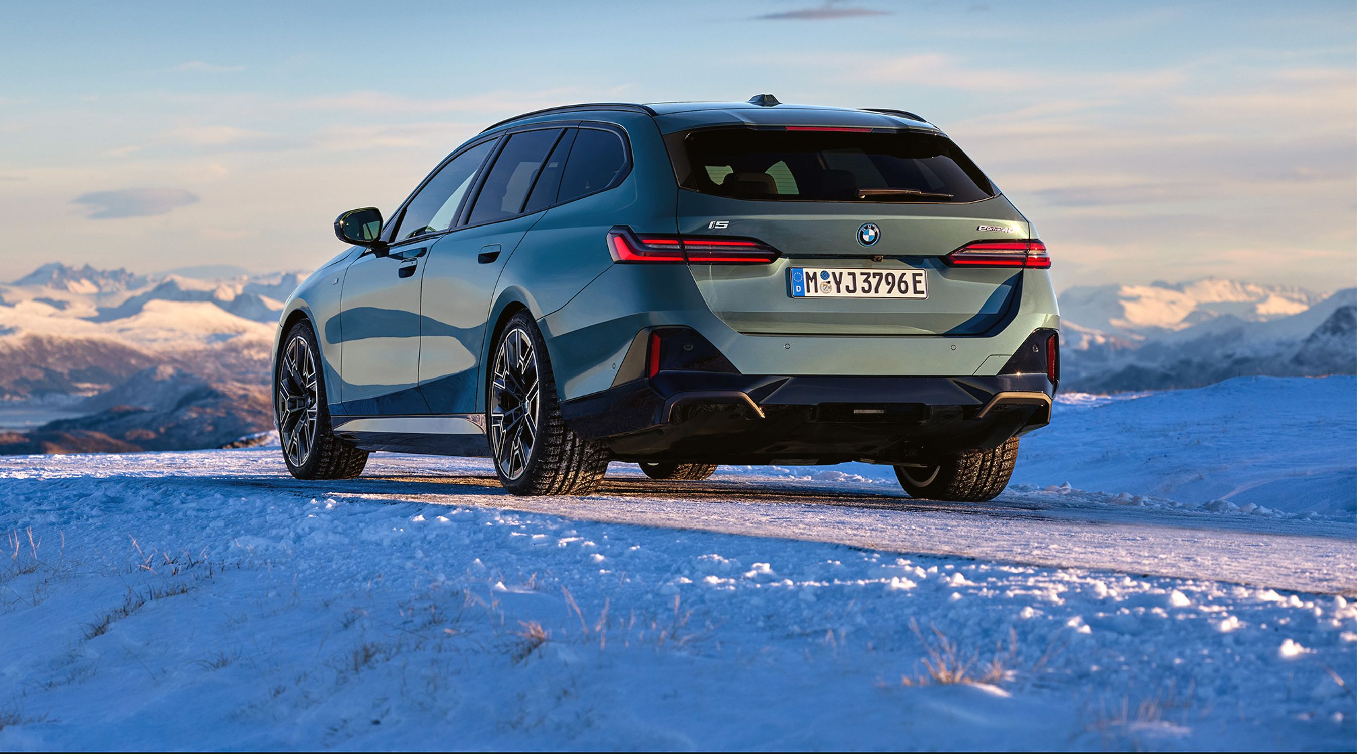 BMW 5-serie stationcar bagfra i snelandskab.