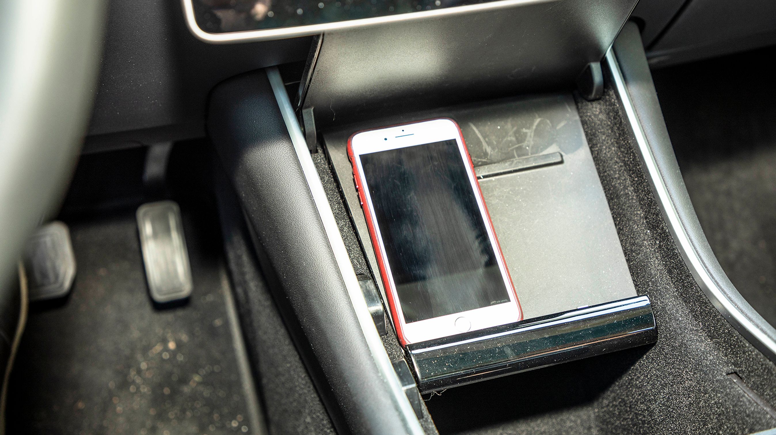 Man kan oplade en mobiltelefon via et stik i midterkonsollen. Der er stik til iPhone og andre mobiler, men Tesla har ikke f.eks. Apple CarPlay.