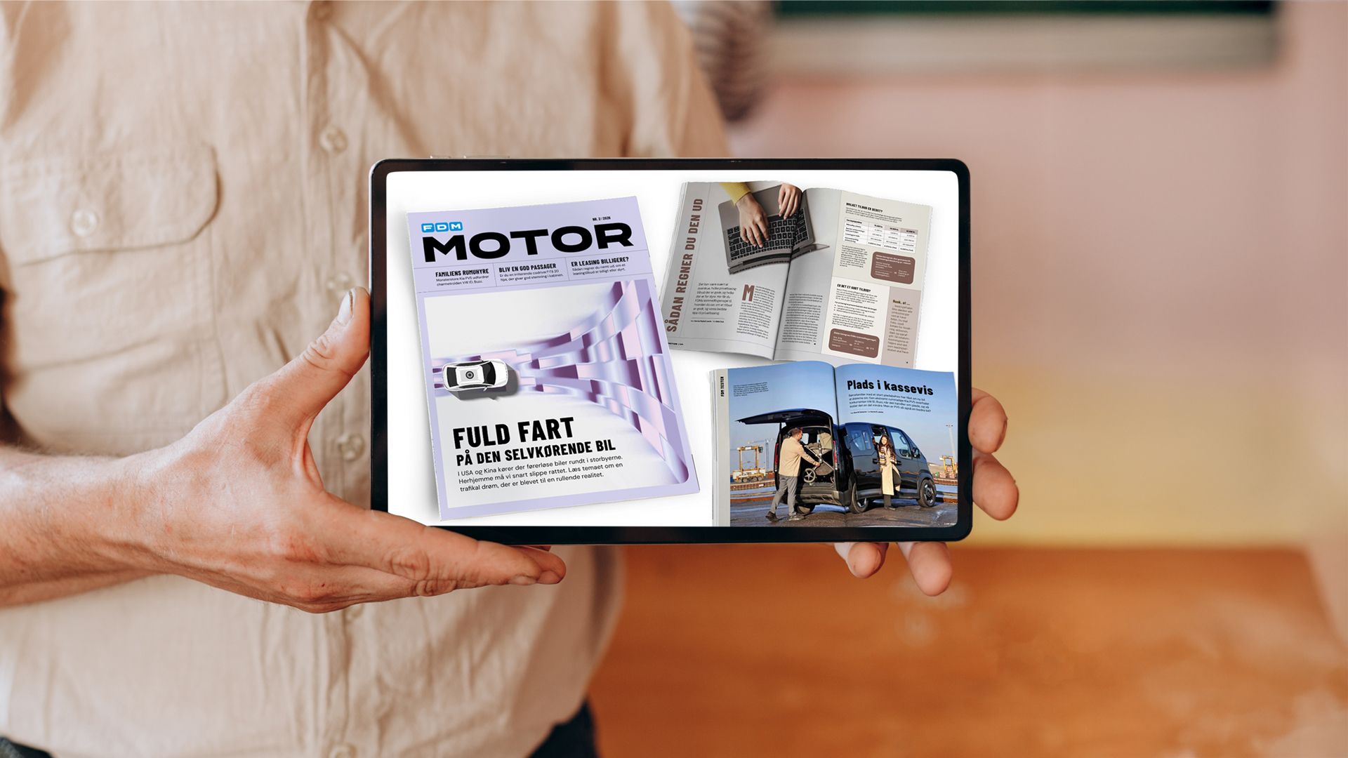 Mand holder iPad med sider fra Motor 2/26
